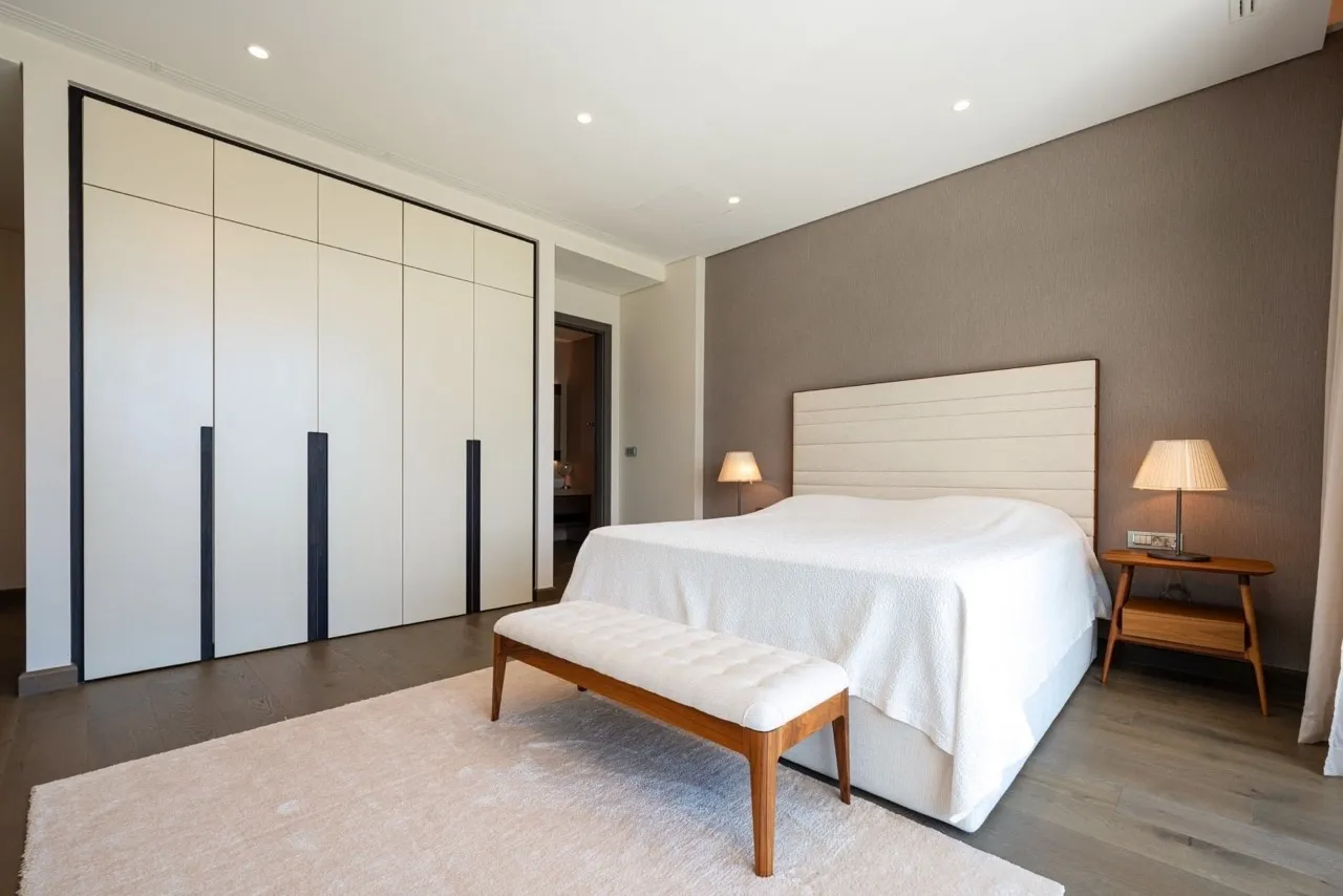 Modernes Schlafzimmer in der Wohnung Portonovi, Kumbor, Montenegro: Doppelbett, Einbauschrank und Parkettboden.