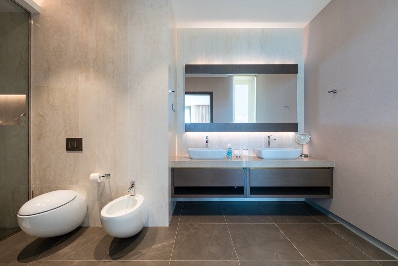 Modern bathroom in Portonovi apartments, Kumbor, Montenegro: two sinks, bidet, and stylish finishes.