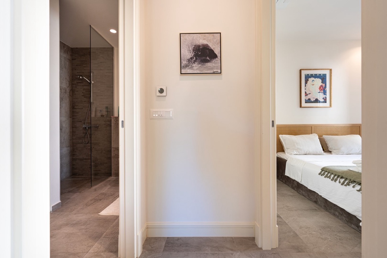 Innenraum einer modernen Wohnung in Luštica Bay, Tivat, Montenegro: Blick auf das Schlafzimmer und das Badezimmer mit Duschkabine.
