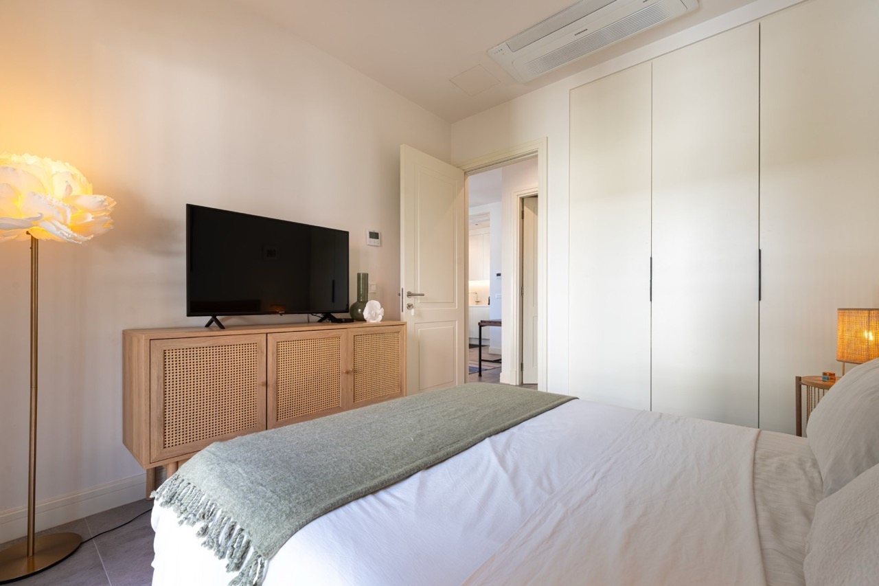 Modernes Schlafzimmer in der Wohnung Luštica Bay, Tivat, Montenegro: Doppelbett, Kleiderschrank und TV-Kommode im modernen Stil.