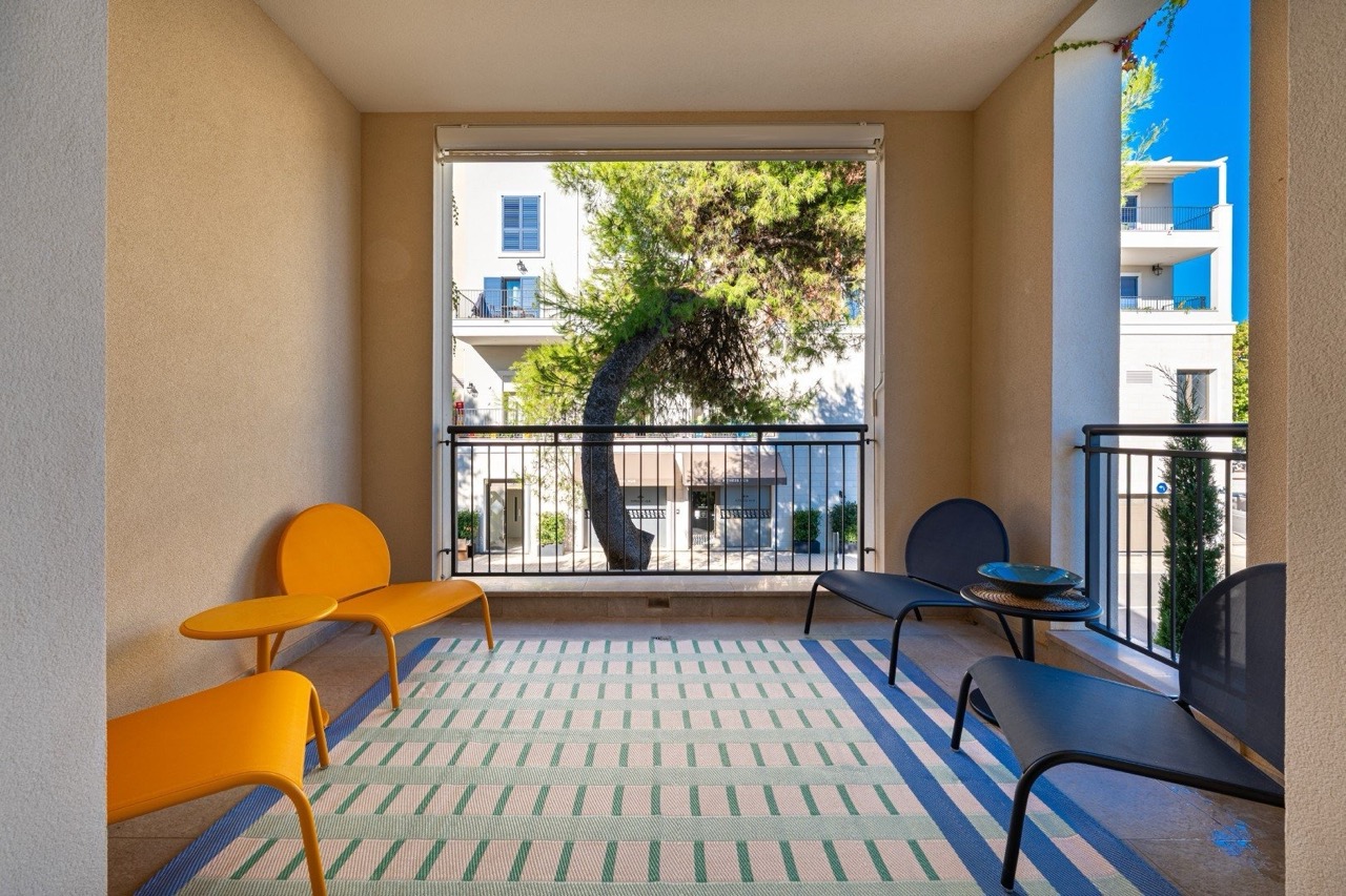 Gemütliche Terrasse mit modernen Möbeln in den Apartments Lustica Bay, Tivat, Montenegro: Blick auf die Stadt und Pinien.