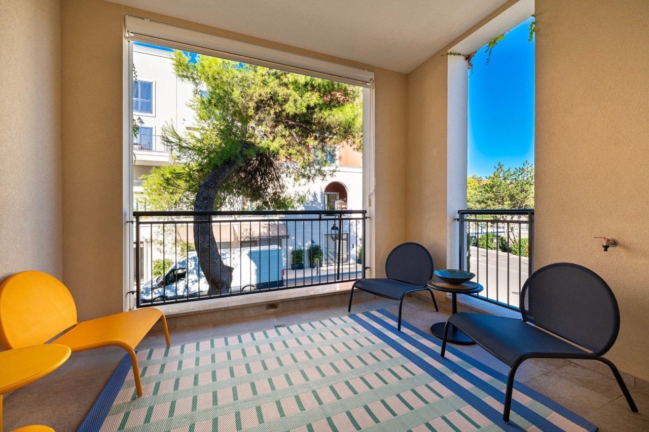 Gemütlicher Balkon mit modernen Möbeln in den Apartments Lustica Bay, Tivat, Montenegro, Blick auf Grün und die Straße.