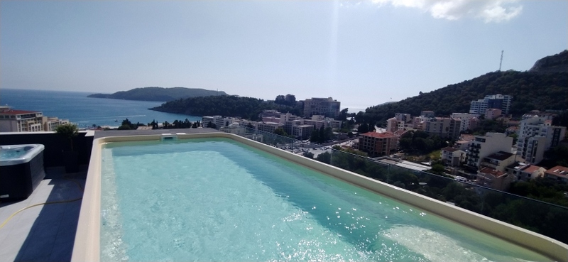 Infinity pool on the apartment terrace in Bečići, Montenegro, with panoramic views of the sea and cityscape.