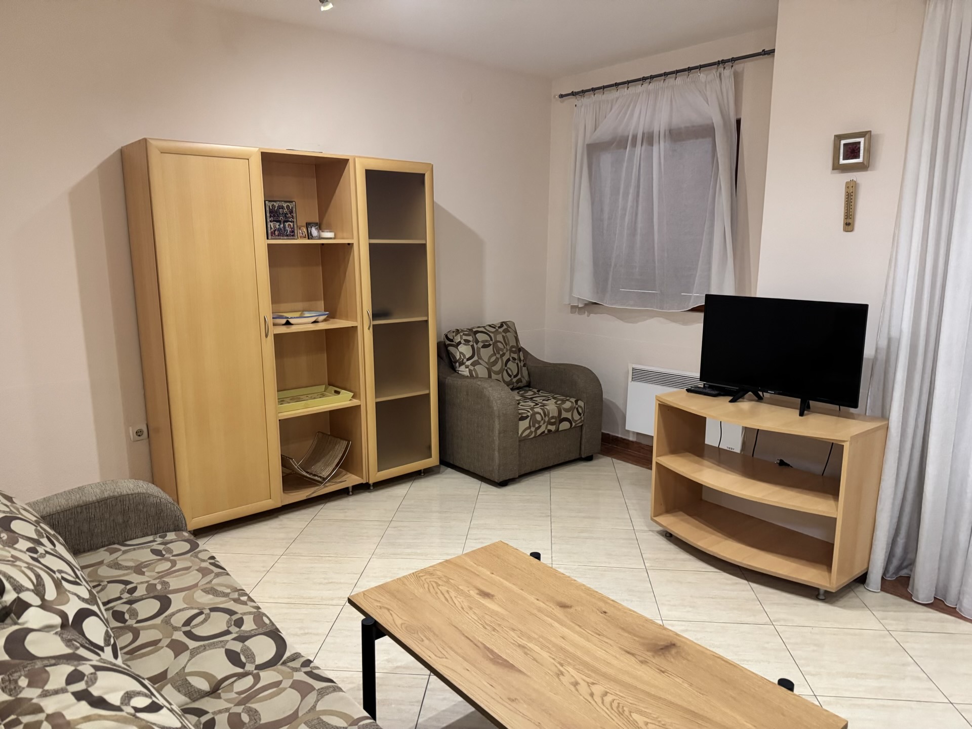 Gemütliches Wohnzimmer mit Möbeln aus hellem Holz in einer zum Verkauf stehenden Wohnung in Budva, Montenegro.