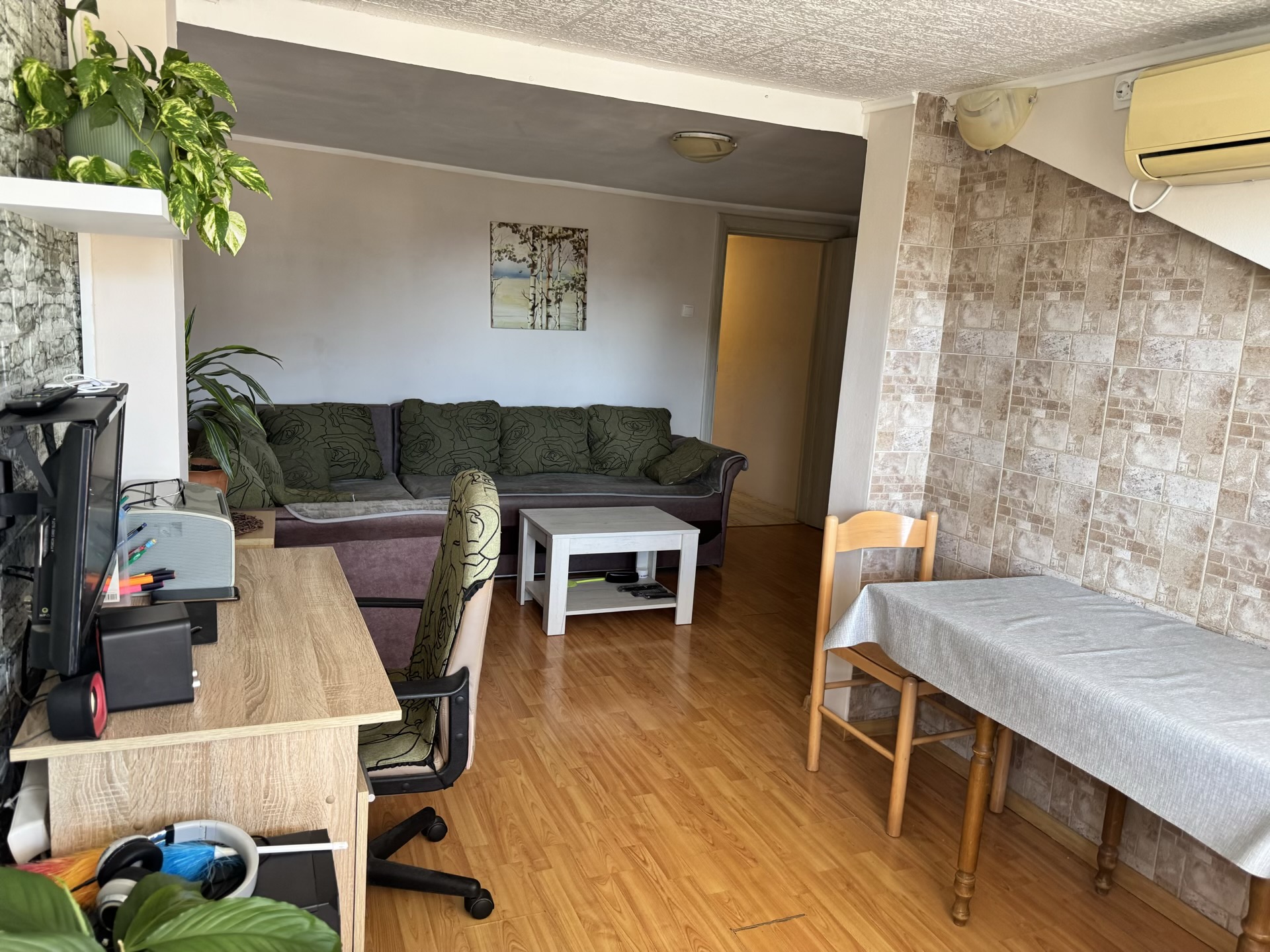 Wohnzimmer in einer Wohnung in Bečići, Montenegro: weiches Sofa, Essbereich, Arbeitsplatz und Parkettboden.