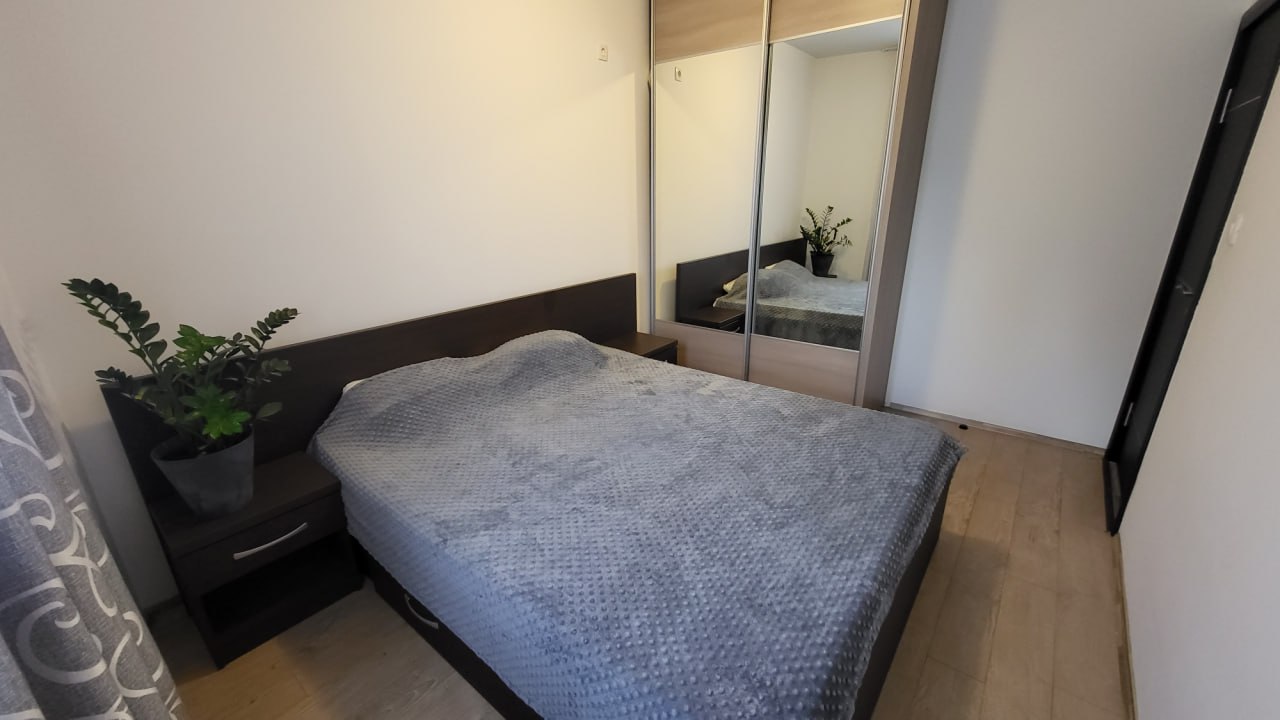 Schlafzimmer in einer Wohnung in Bečići, Montenegro: Doppelbett, Kleiderschrank mit Spiegel und Nachttisch.