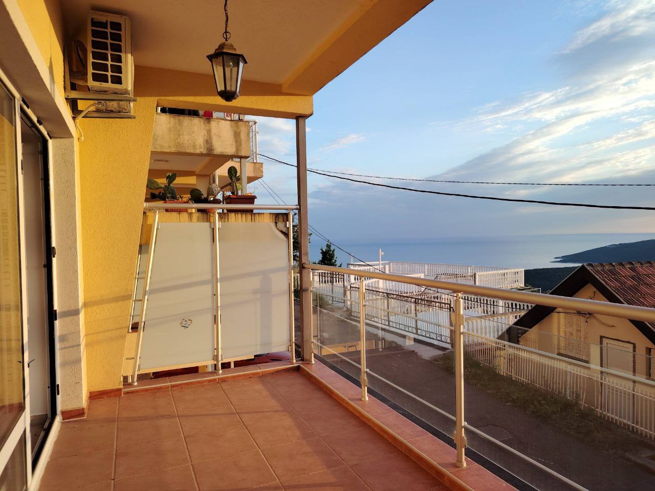 Balcon spacieux avec vue panoramique sur la mer dans un appartement, Seoc, Monténégro : sol carrelé et garde-corps en verre.