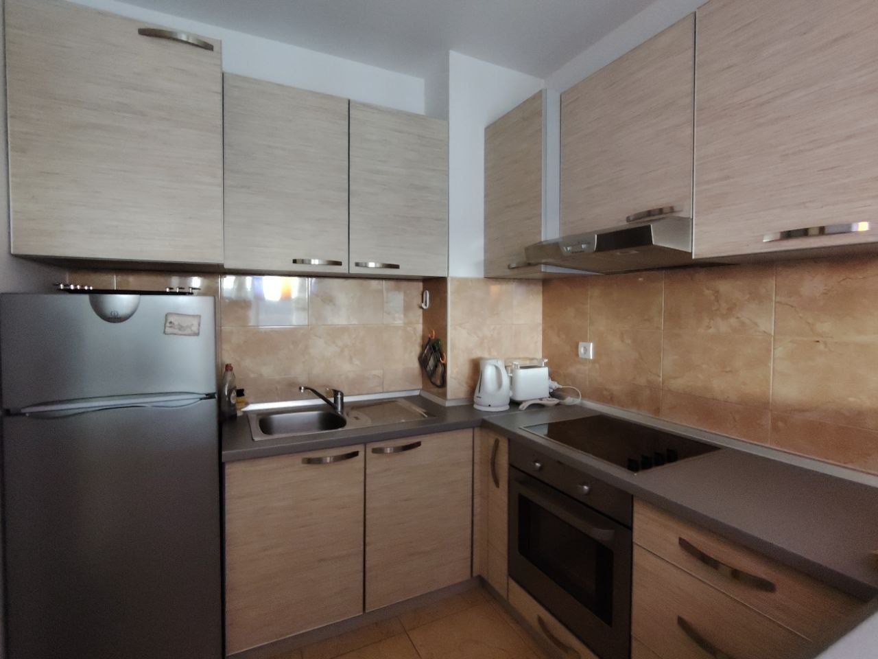 Cuisine moderne dans un appartement, Sceoce, Monténégro : mobilier clair, électroménager intégré, réfrigérateur et cuisinière.
