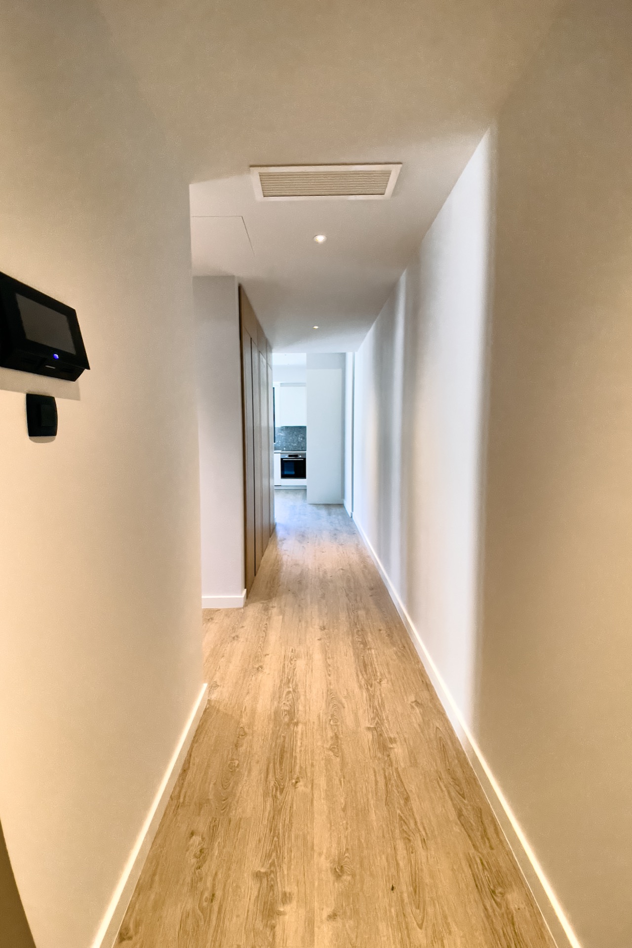 Heller Flur in einer modernen Wohnung in Porto Montenegro, Tivat, Montenegro, mit Holzboden und Einbaumöbeln.