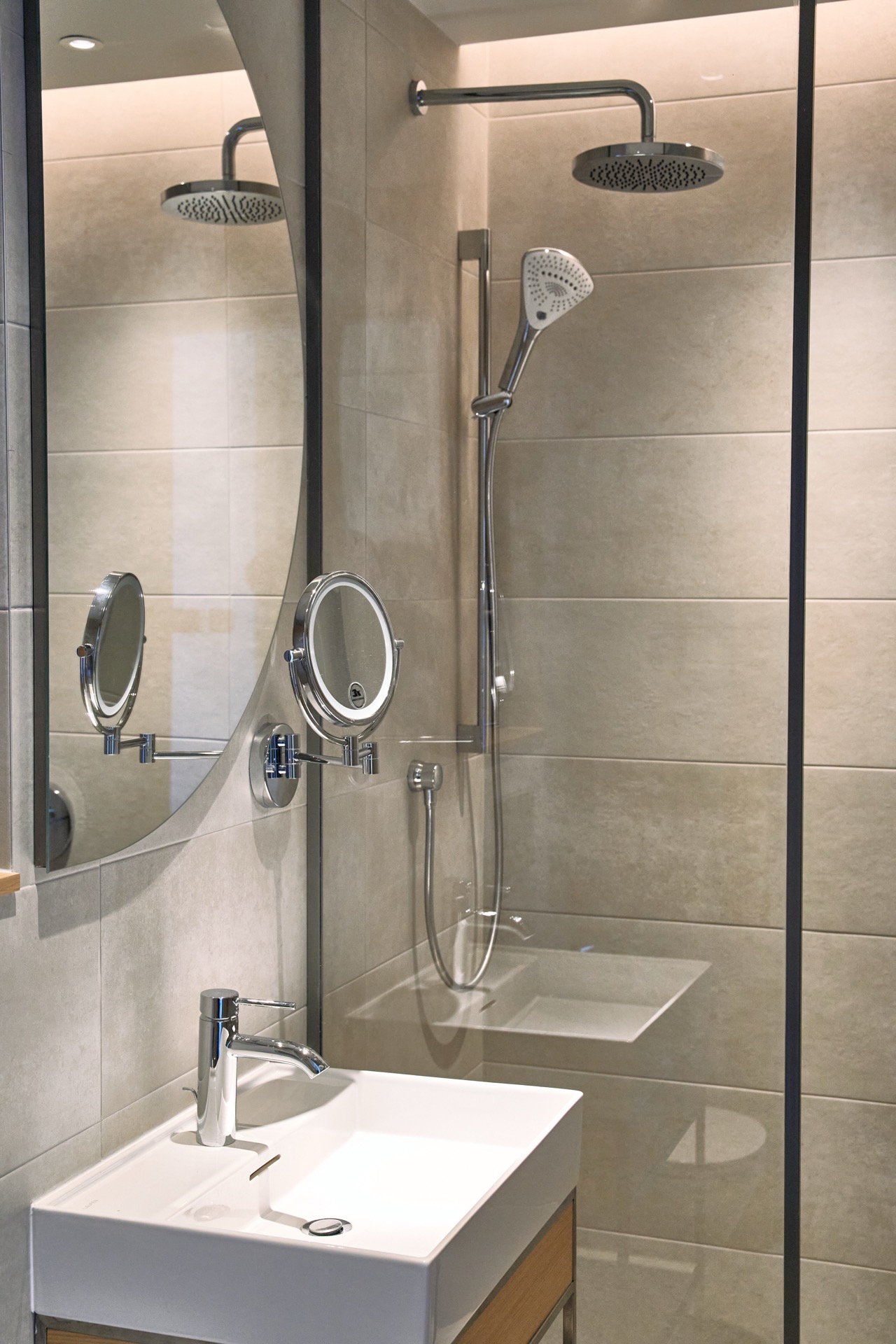 Modernes Badezimmer in einer Wohnung in Porto Montenegro, Tivat, Montenegro: Duschkabine, stilvolle Sanitäranlagen und Spiegel.