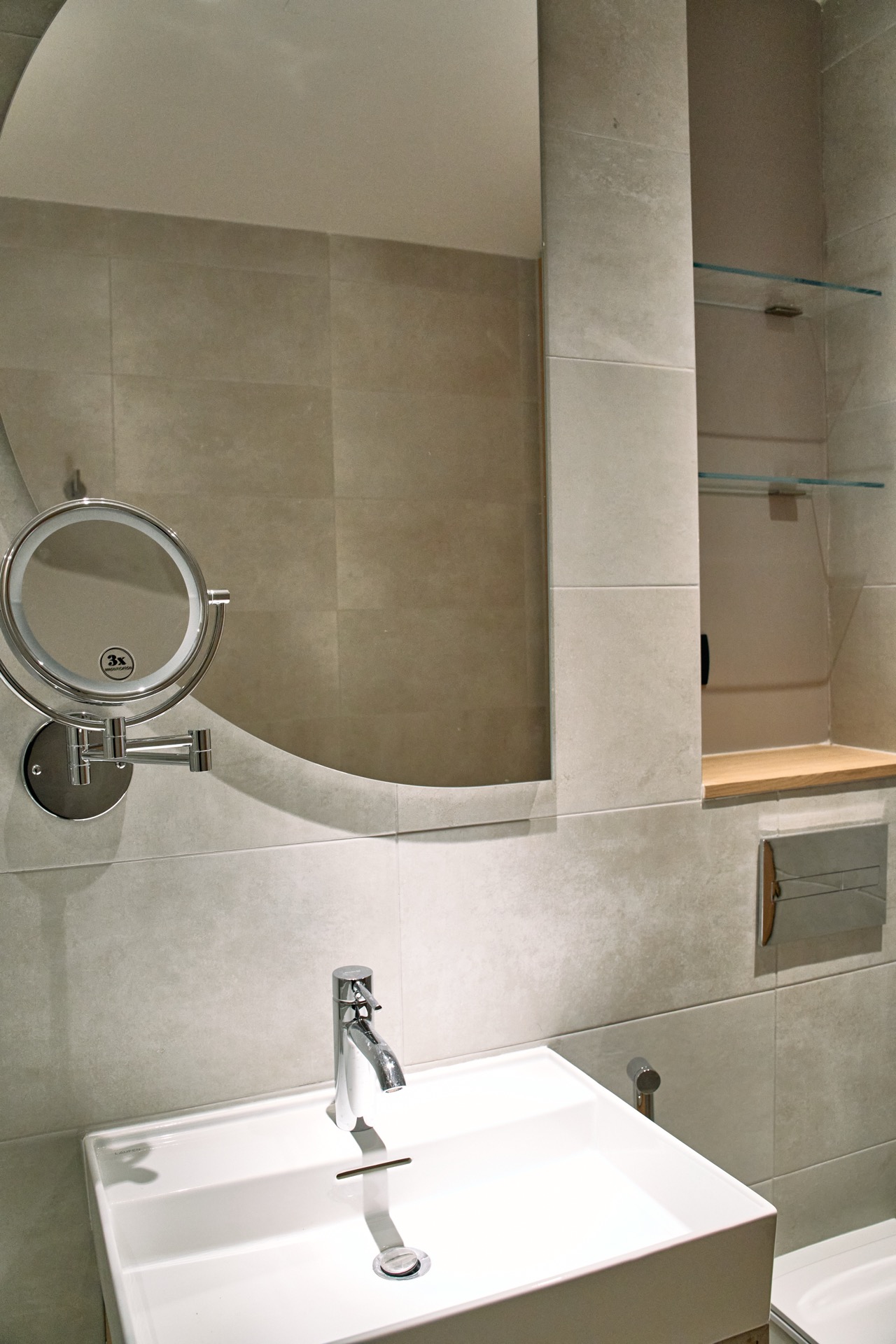 Modernes Badezimmer in einer Wohnung in Porto Montenegro, Tivat, Montenegro: stilvolles Waschbecken, Spiegel und Regale.