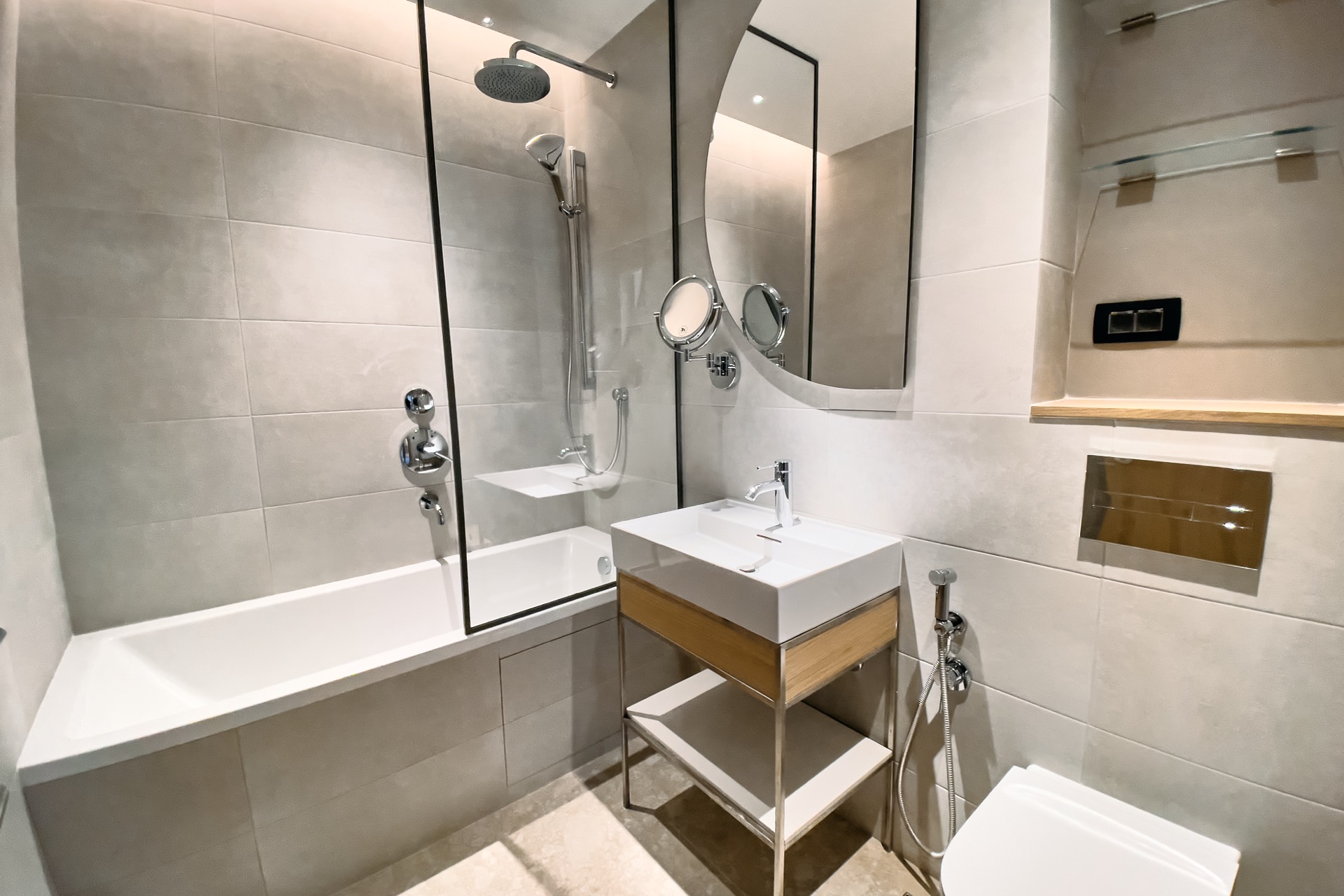Modernes Badezimmer in einer Wohnung in Porto Montenegro, Tivat, Montenegro: Badewanne, Glasabtrennung und stilvolle Möbel.