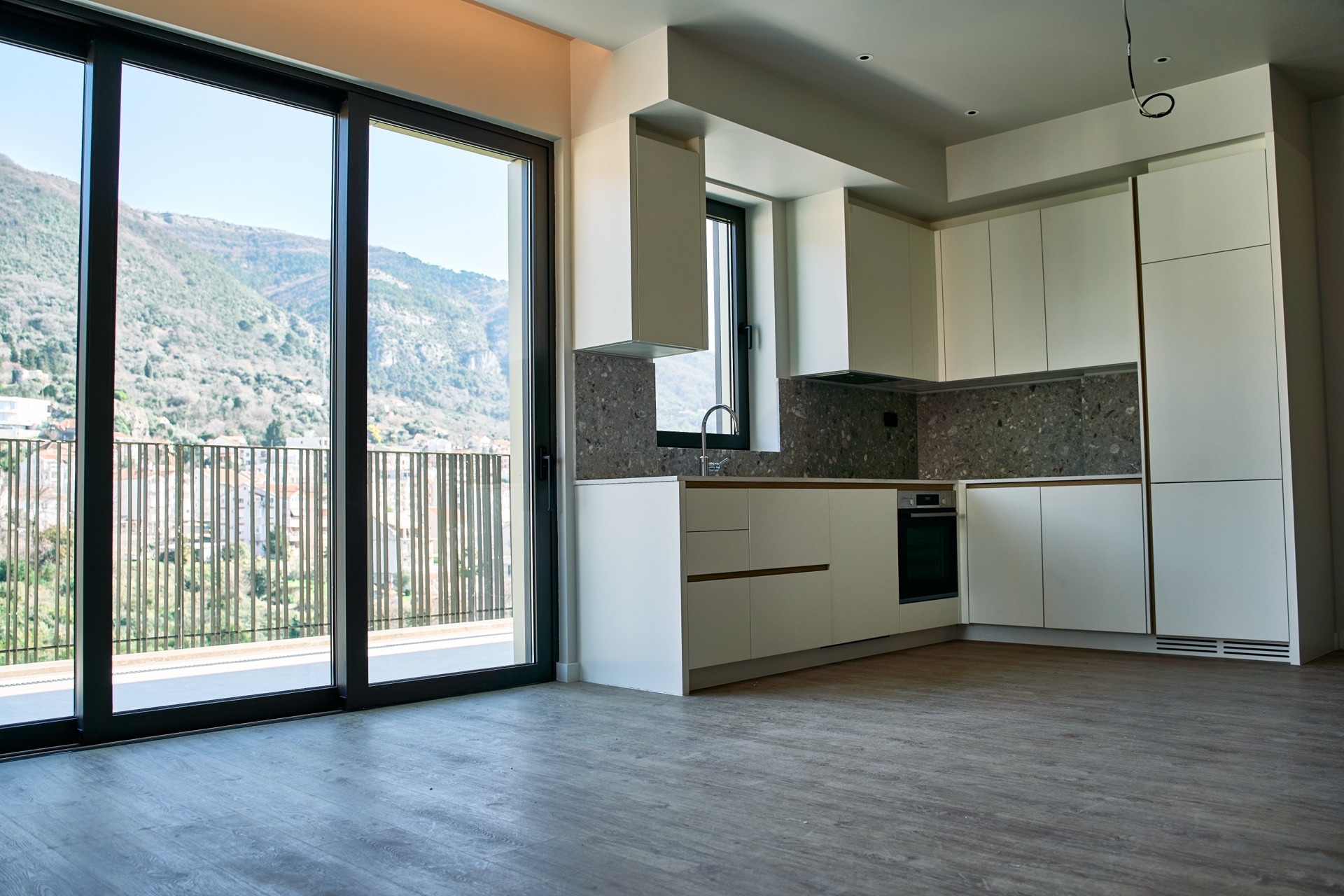 Moderne Küche in einer Wohnung in Porto Montenegro, Tivat, Montenegro: helle Möbel, Bergblick und Panoramafenster.