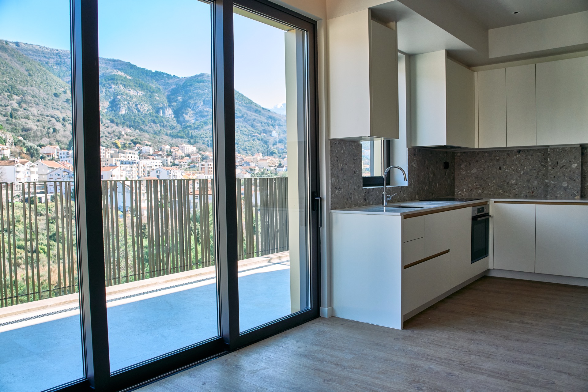 Moderne Küche in einer Wohnung in Porto Montenegro, Tivat, Montenegro, mit Panoramablick auf die Berge und Terrasse.