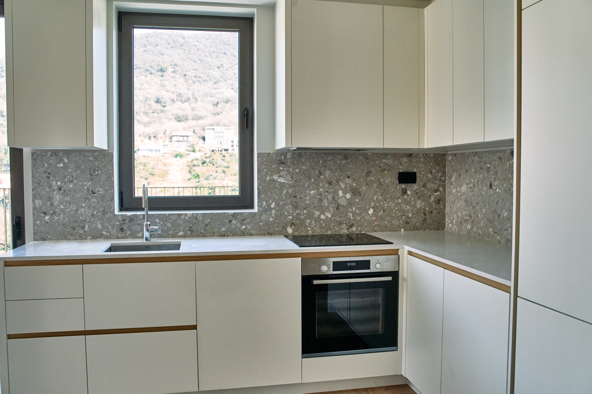 Moderne Küche mit Steinrückwand und Bergblick in einer Wohnung in Porto Montenegro, Tivat, Montenegro.