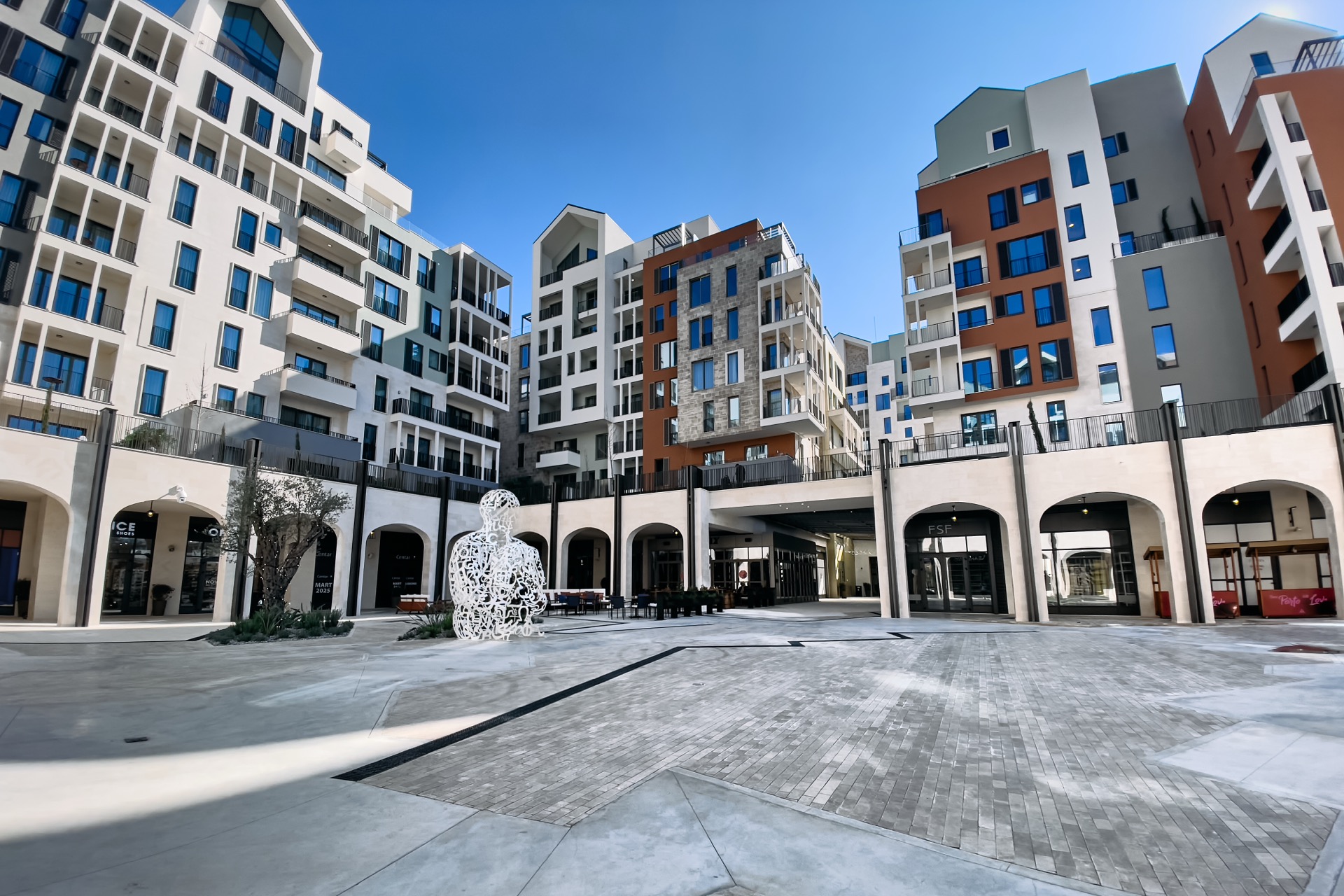 Moderner Wohnkomplex in Porto Montenegro, Tivat: Architektur der Gebäude, Kunstobjekt auf dem Platz und Einkaufsgalerien.
