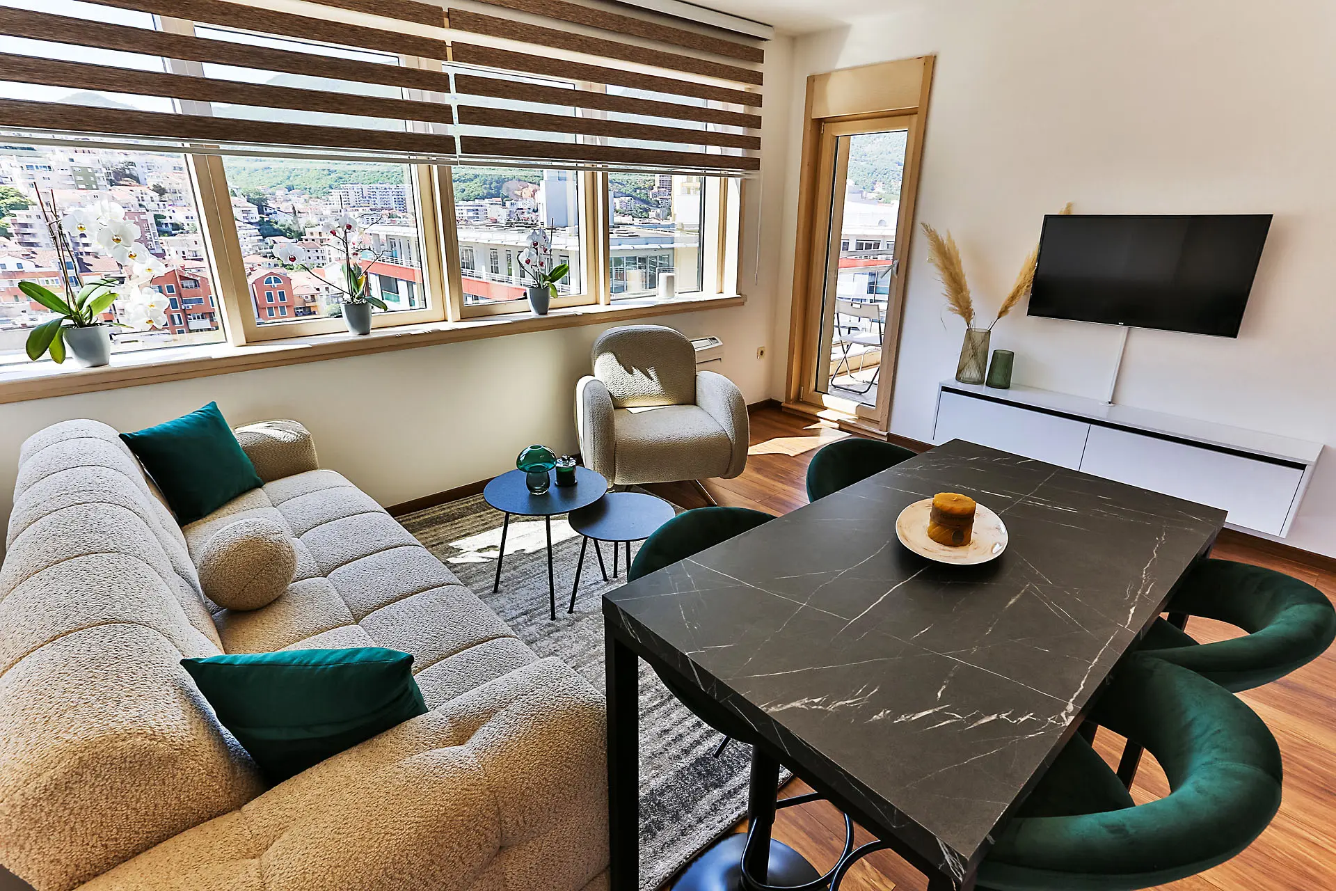 Modernes Wohnzimmer mit Panoramafenstern in einer Wohnung in Budva, Montenegro: Essbereich und Polstermöbel.