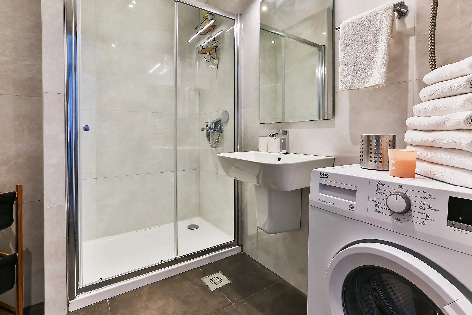 Modernes Badezimmer mit Duschkabine und Waschmaschine in einer Wohnung, Stadt Budva, Montenegro.