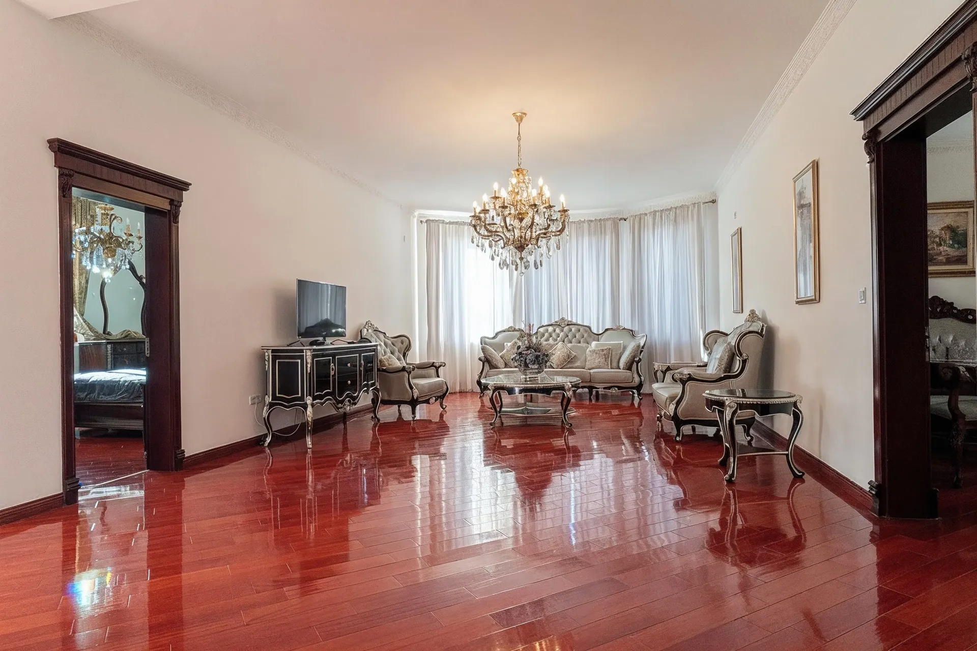 Elegantes Wohnzimmer mit glänzendem Parkettboden, Kristalllüster und klassischer Möbelausstattung.