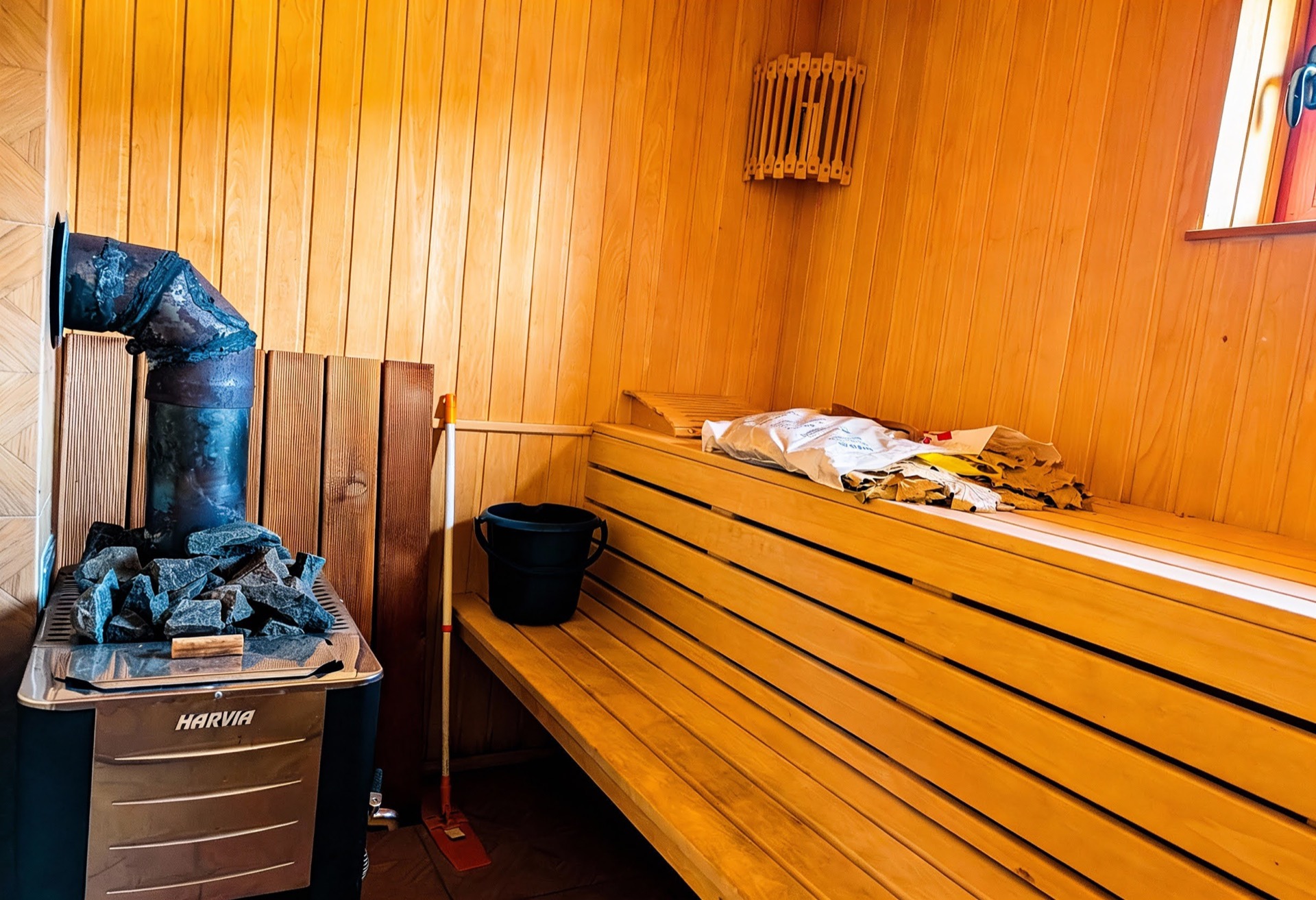Holzsauna mit Harvia-Ofen in einer Villa in Luštica Bay, Montenegro: Verkleidung mit Holzpaneelen, Bänke und Sauna-Accessoires.