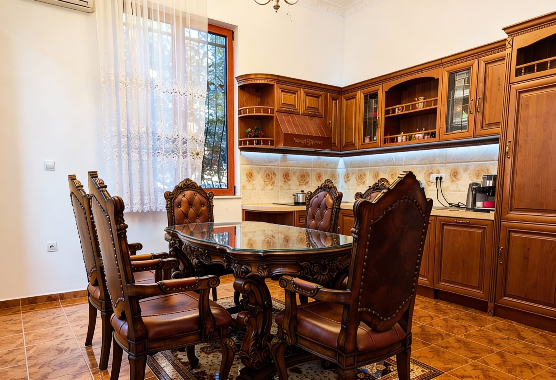 Klassische Küche mit geschnitzten Holzmöbeln und Essbereich in einer Villa in Luštica, Montenegro.