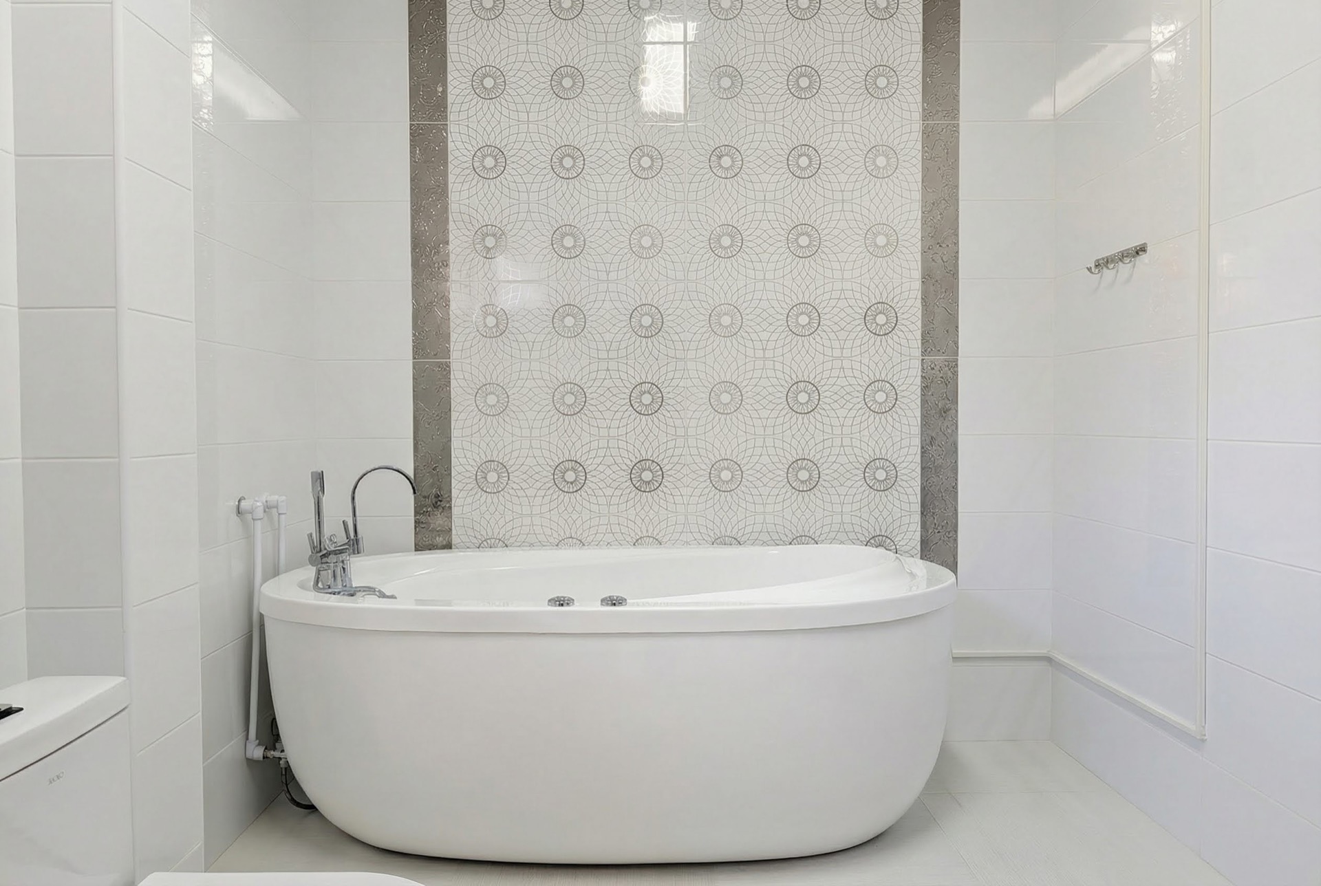 Modernes Badezimmer mit ovaler Badewanne und dekorativen Fliesen in einer Villa in Luštica Bay, Montenegro.