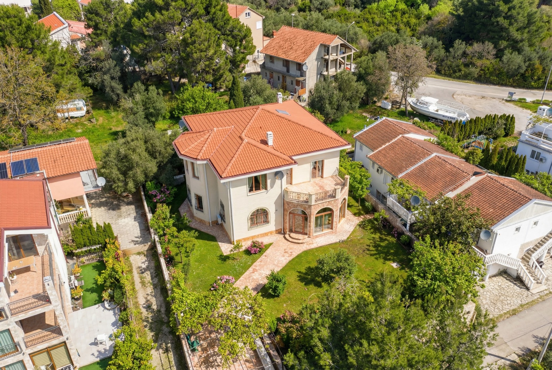 Luftaufnahme einer zweistöckigen Villa mit Ziegeldach und grünem Garten in Luštica, Montenegro.