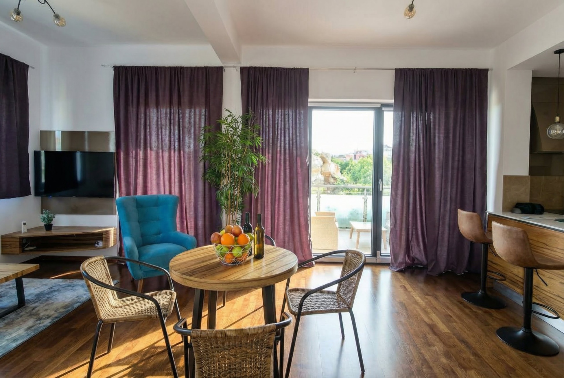 Wohnzimmer mit Essbereich in einer Wohnung in Bečići, Montenegro: moderne Möbel, Korbstühle und Zugang zur Terrasse.