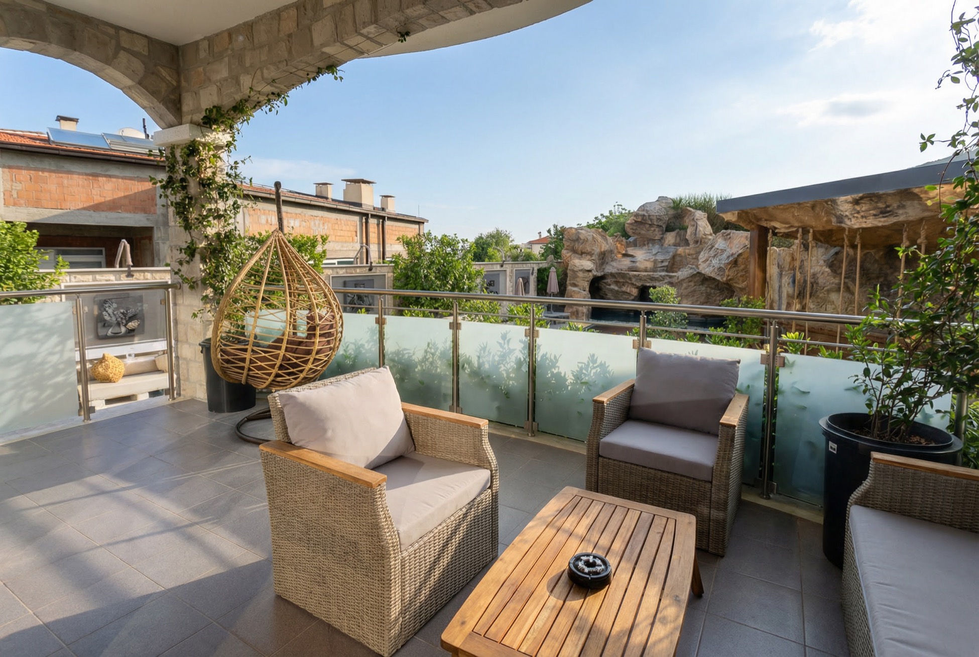 Gemütliche Terrasse mit Korbmöbeln und Blick auf die Felsen in einer Wohnung in Bečići, Montenegro.