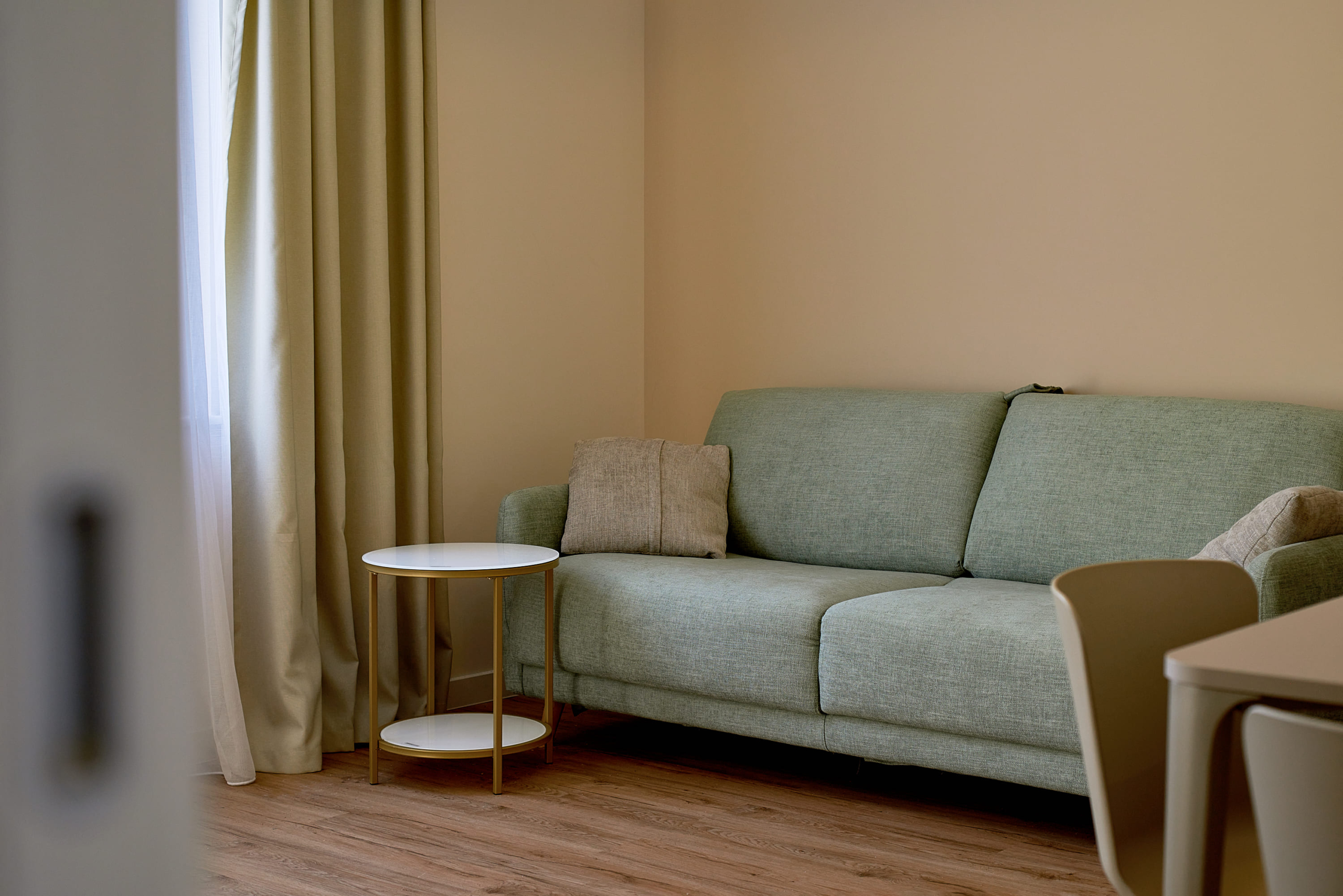 Salon lumineux avec canapé vert et table basse dans un appartement, Bečići, Monténégro.