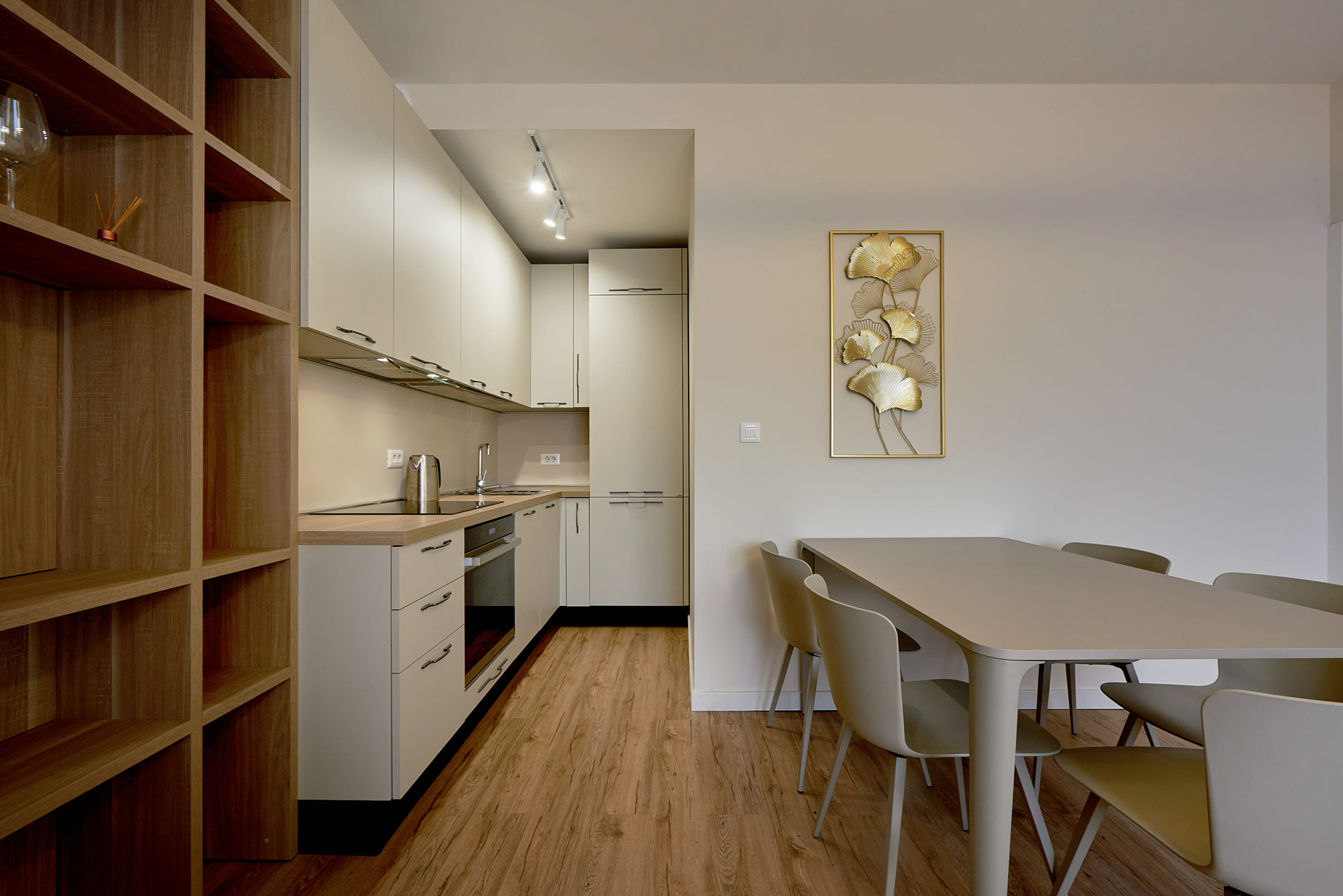 Cuisine moderne dans un appartement à Bečići, Monténégro : meubles de cuisine clairs, coin repas et décoration murale.