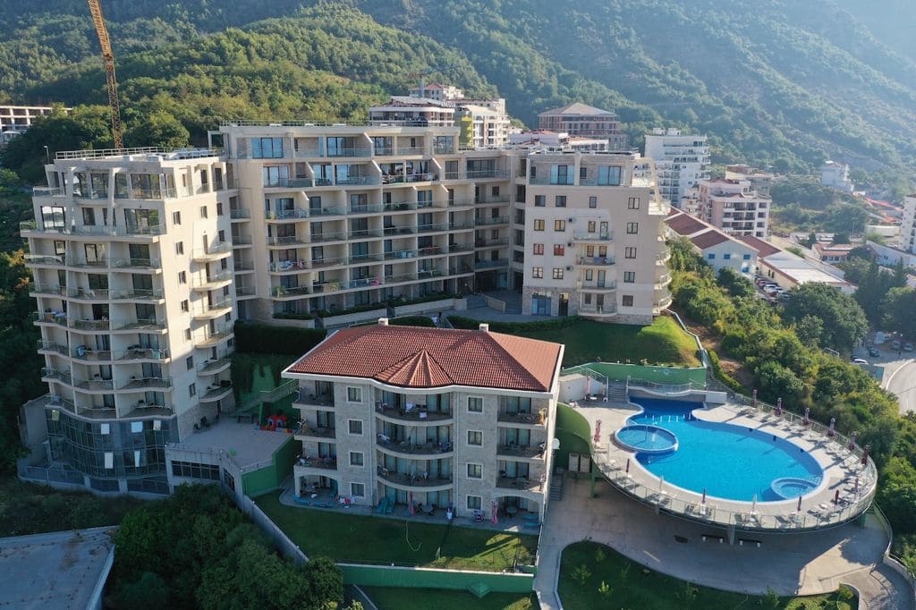 Complexe résidentiel à Bečići, Monténégro : appartements modernes avec terrasses, piscine extérieure et vue sur les montagnes.