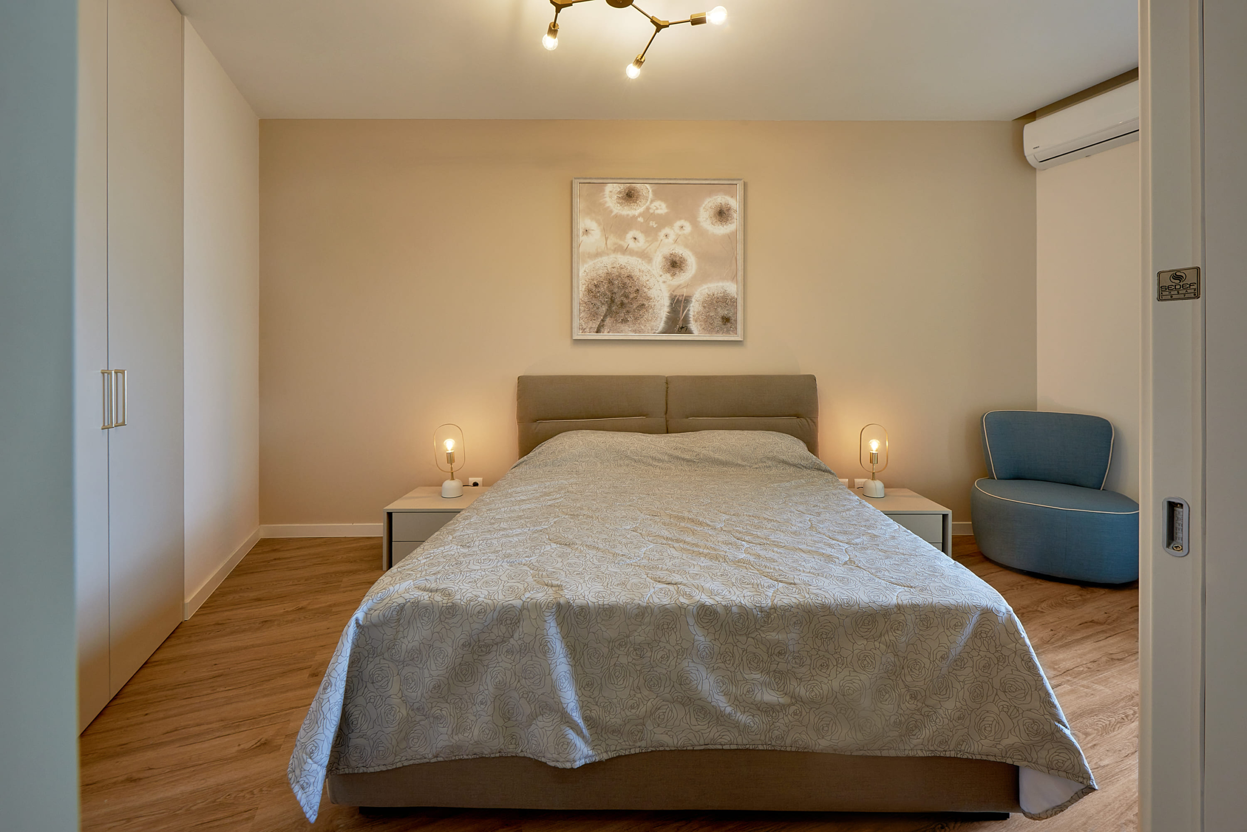 Chambre moderne avec lit double dans l'appartement à Bečići, Monténégro : intérieur élégant et mobilier confortable.