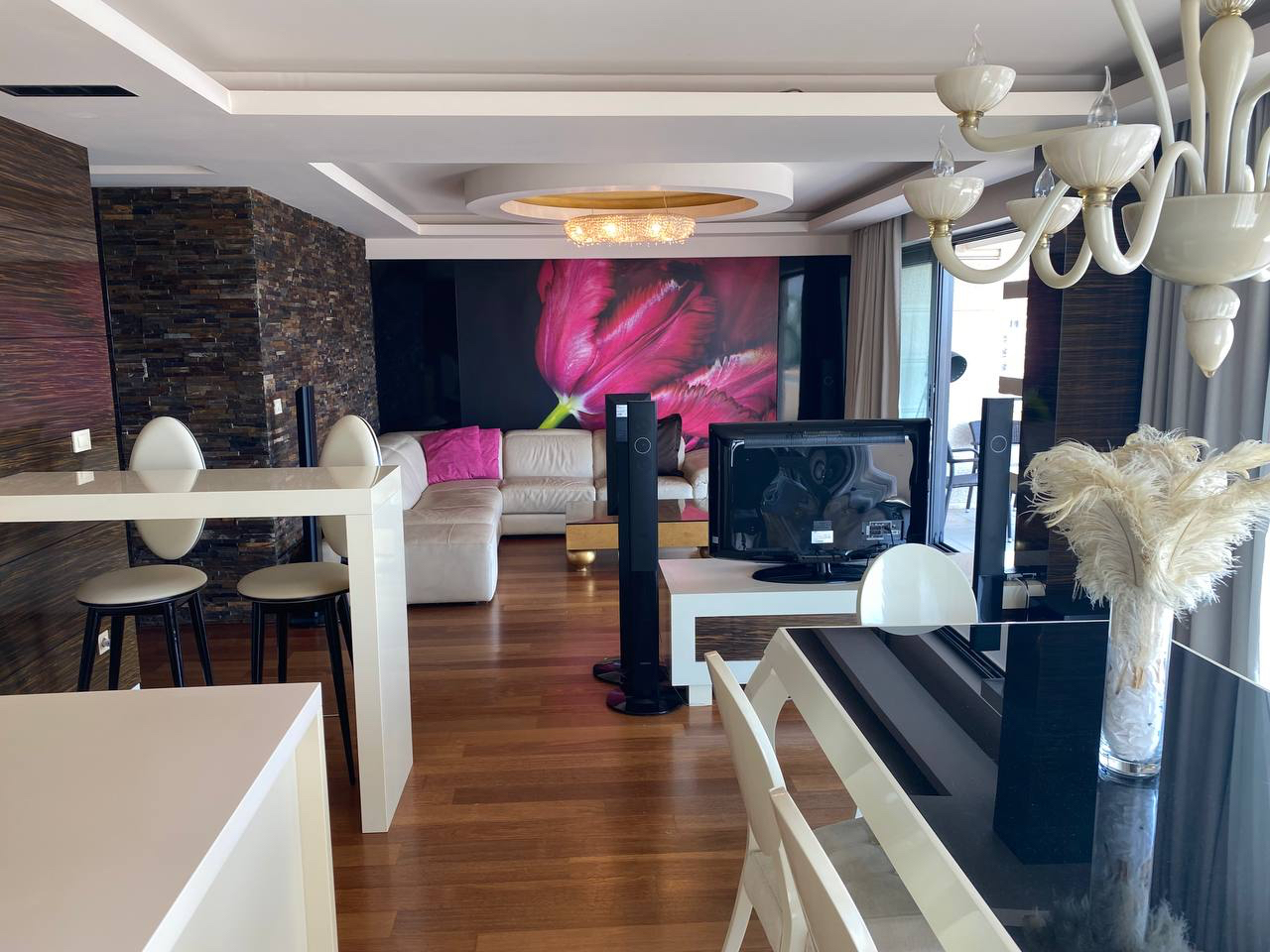 Przestronny salon z miękką sofą, strefą TV i stołem jadalnym w ekskluzywnym apartamencie w Budvie, Czarnogóra