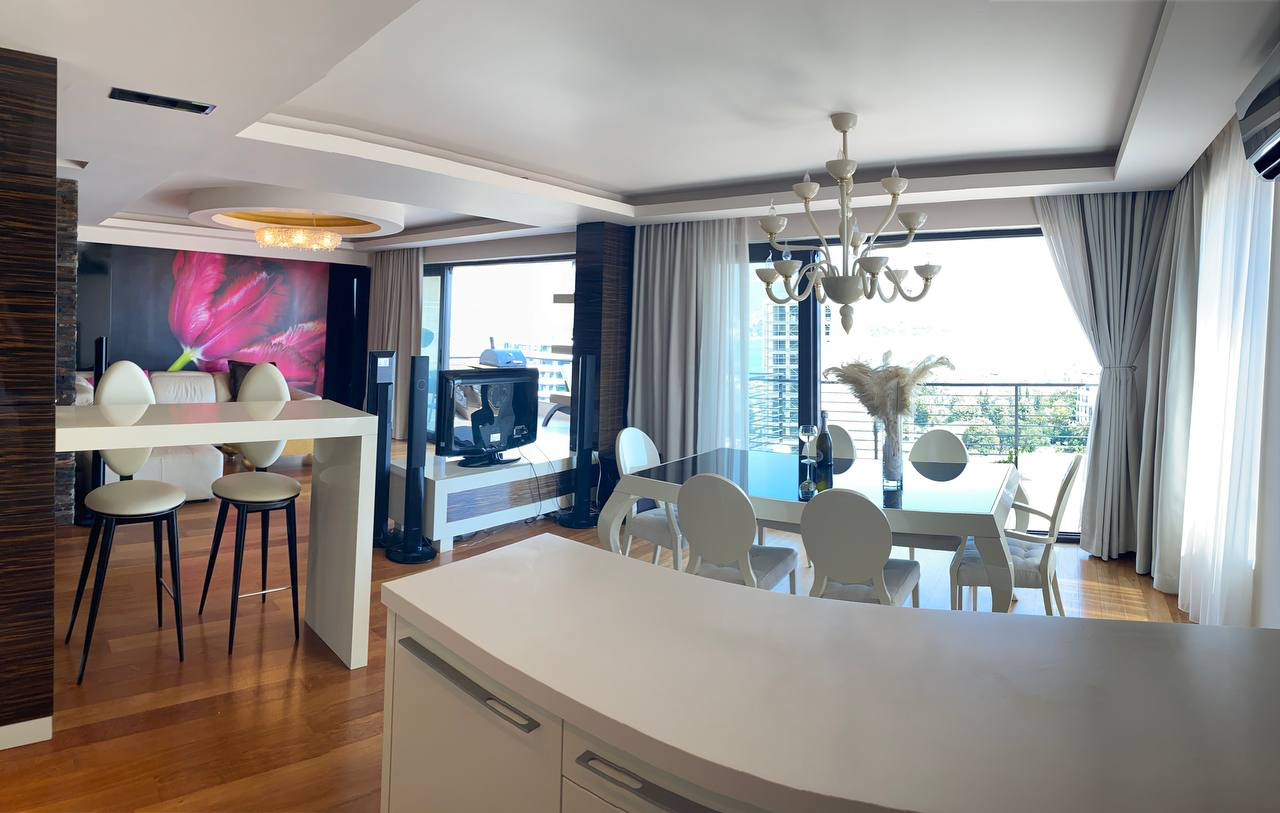 Nowoczesny salon z panoramicznymi oknami i meblami w ekskluzywnym apartamencie w Budvie, Czarnogóra