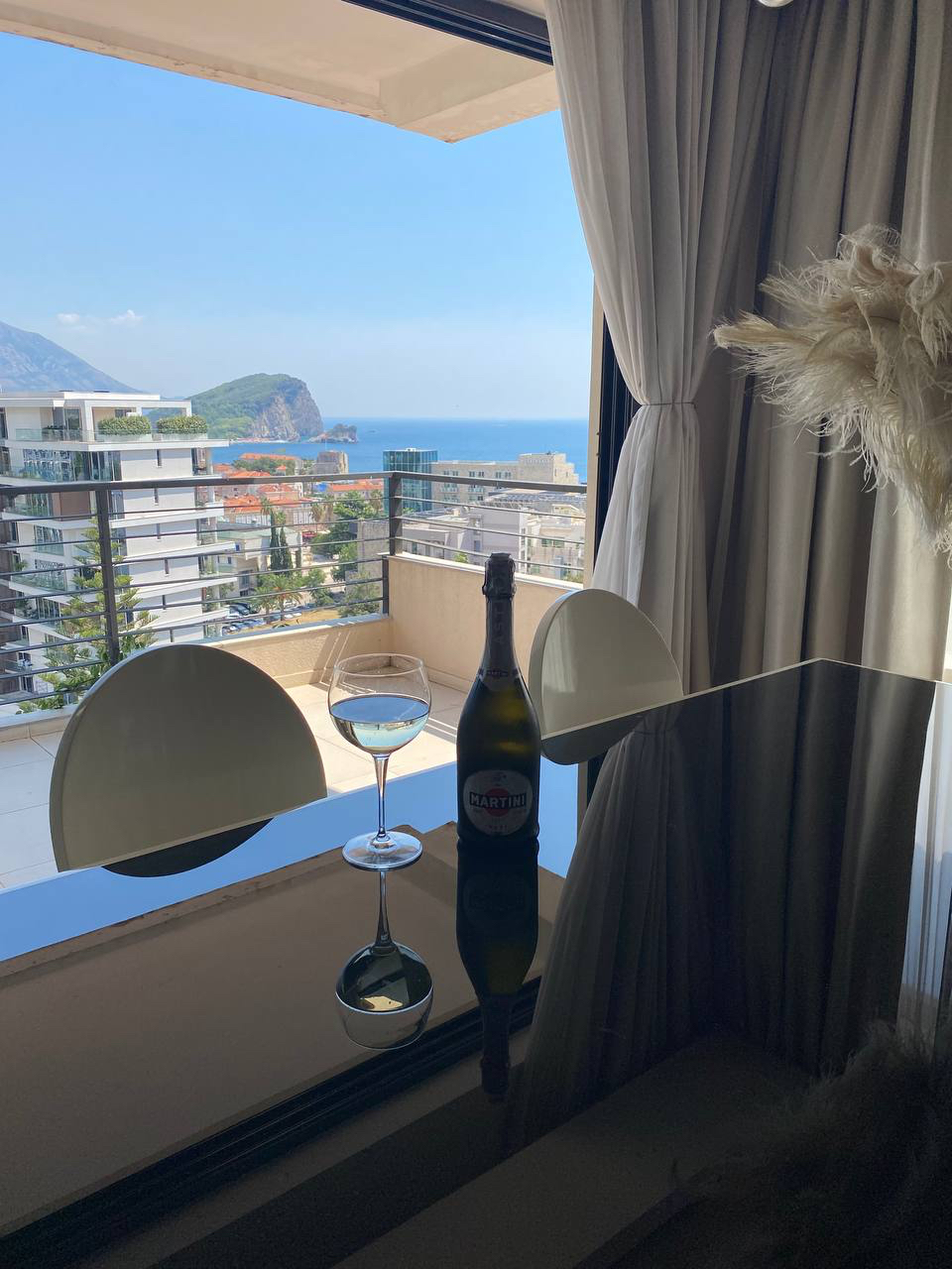 Widok na morze i miasto z balkonu nowoczesnego salonu w apartamencie w Budvie, Czarnogóra