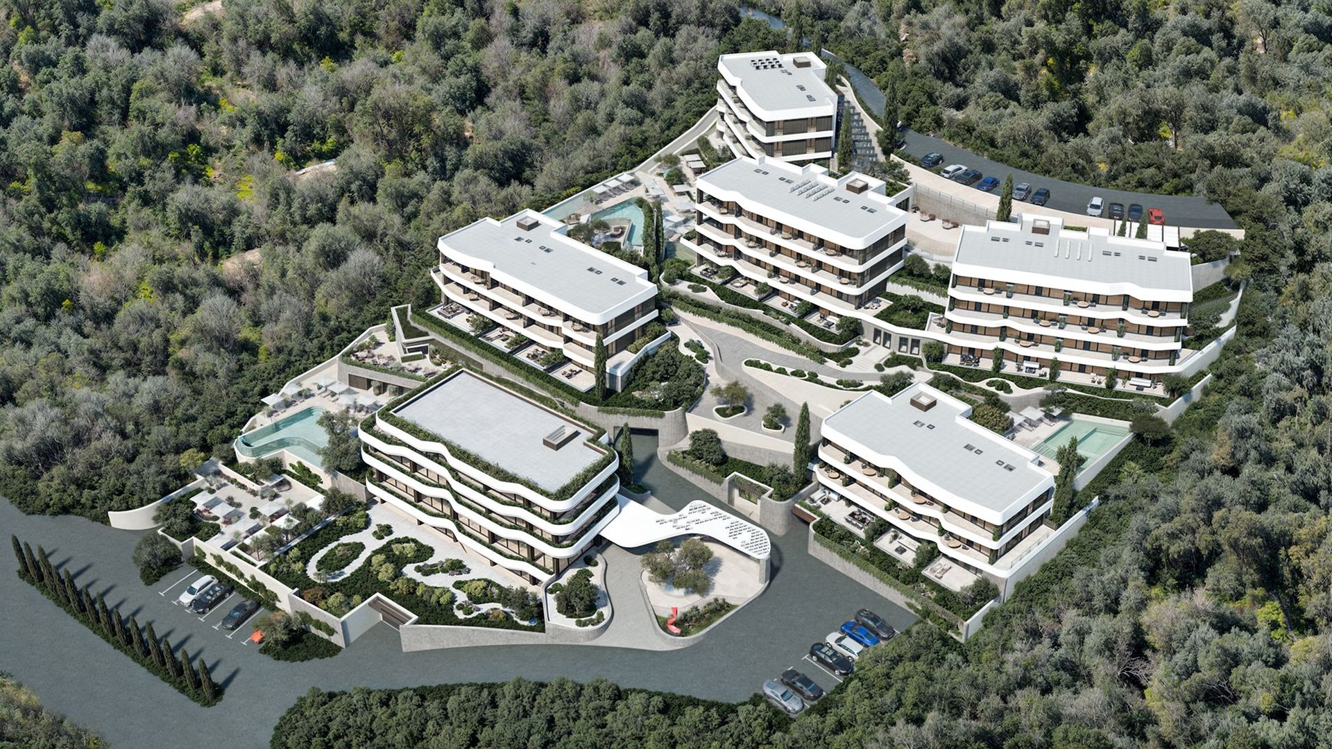 Vue d’en haut d’un complexe résidentiel moderne à Reževići, Monténégro : immeubles de faible hauteur, piscines et aménagement paysager.