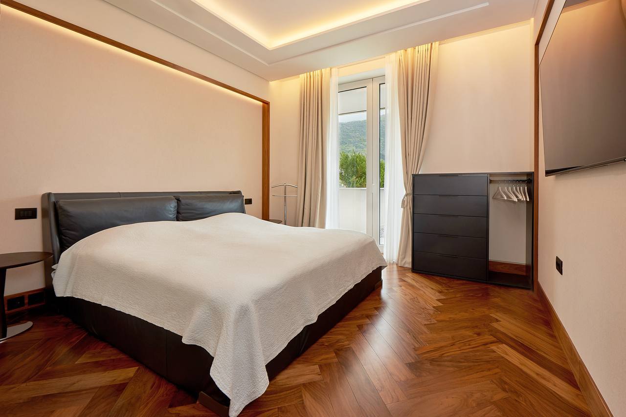 Modernes Schlafzimmer mit Doppelbett und Parkett in einer Wohnung in Porto Montenegro, Tivat, Montenegro.