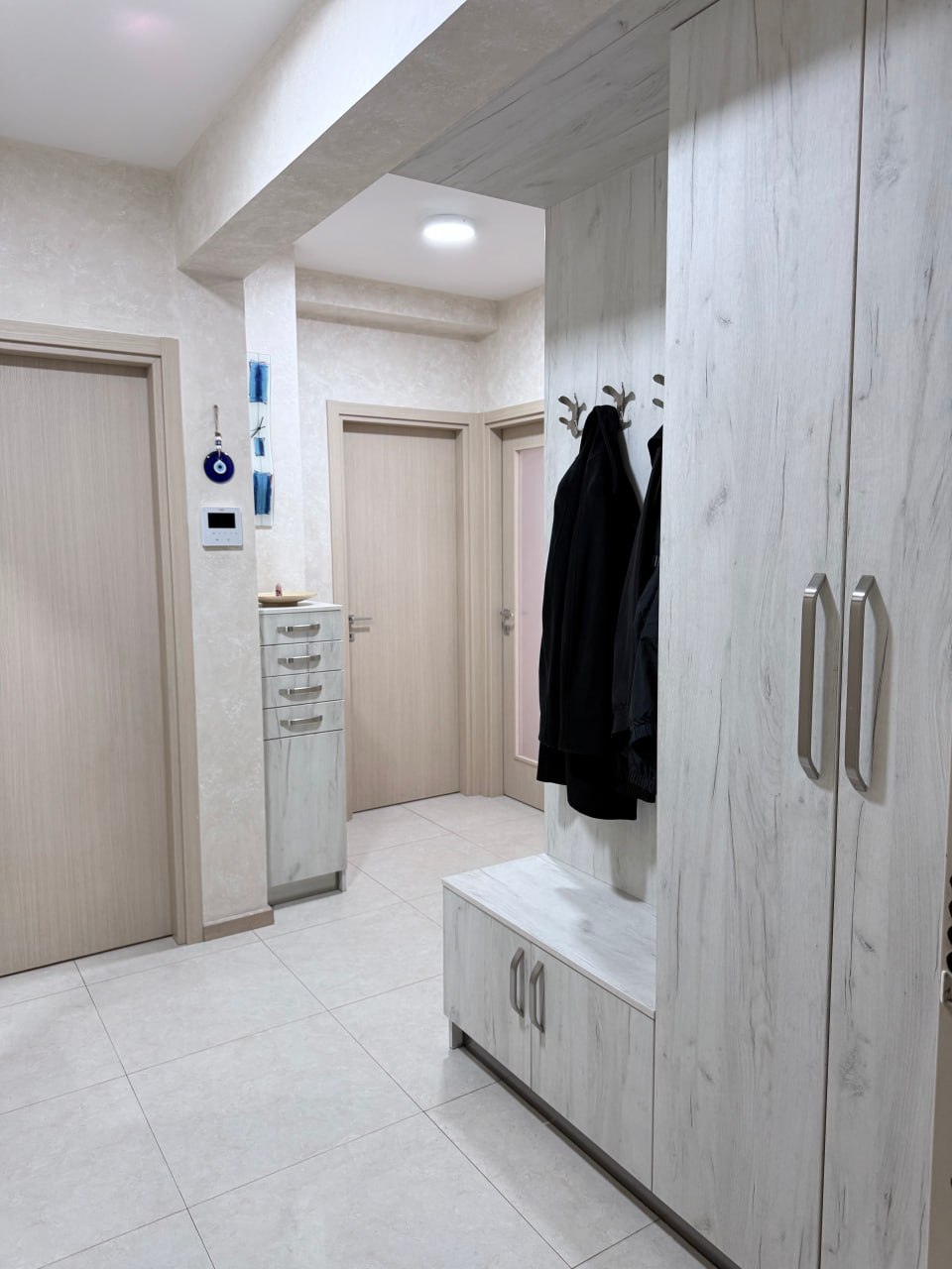 Entrée lumineuse avec placard intégré et meubles en bois dans un appartement à Podgorica, Monténégro.