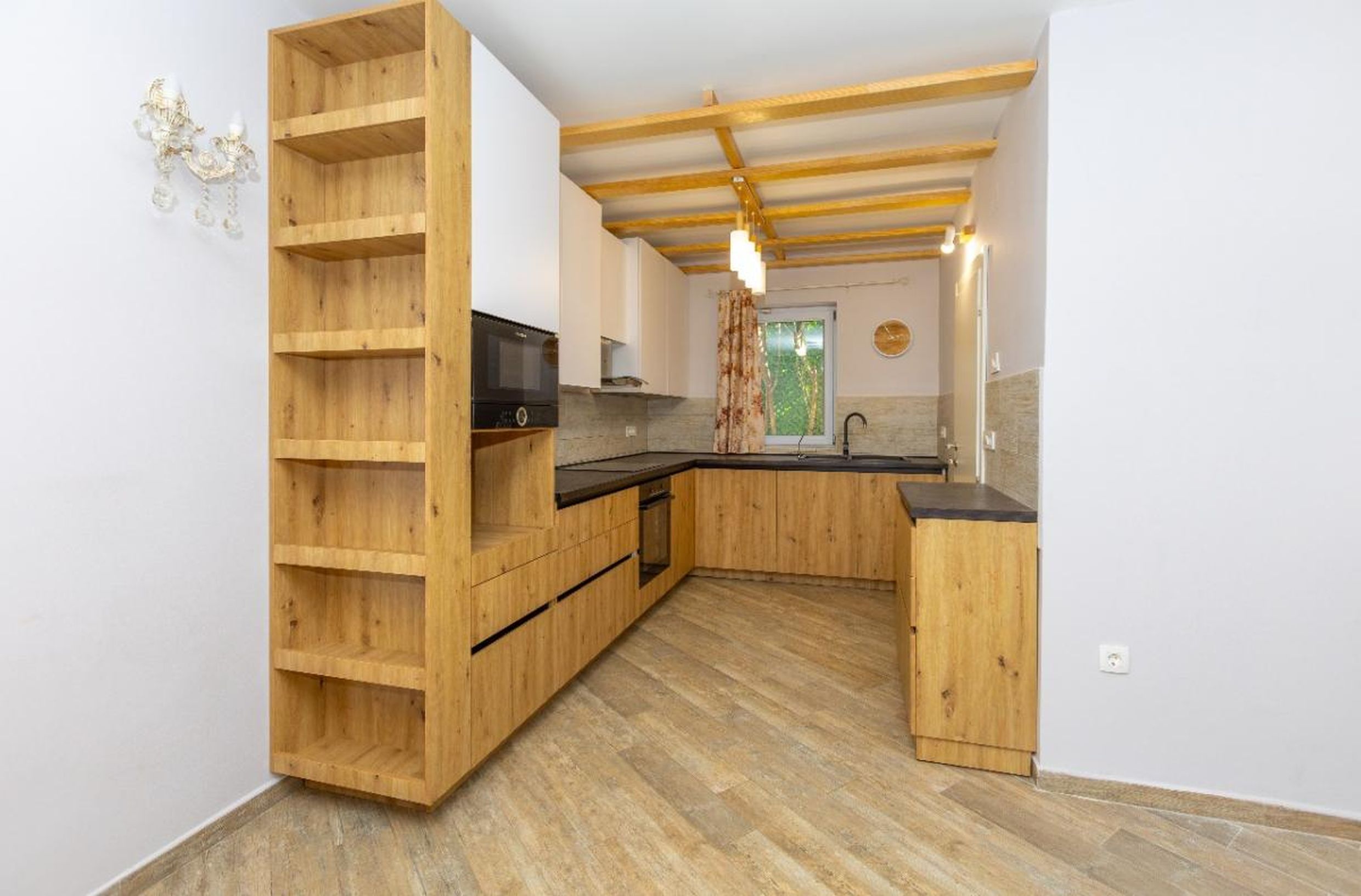 Cuisine moderne avec façades en bois et poutres apparentes au plafond dans une maison à vendre, Tivat, Monténégro.