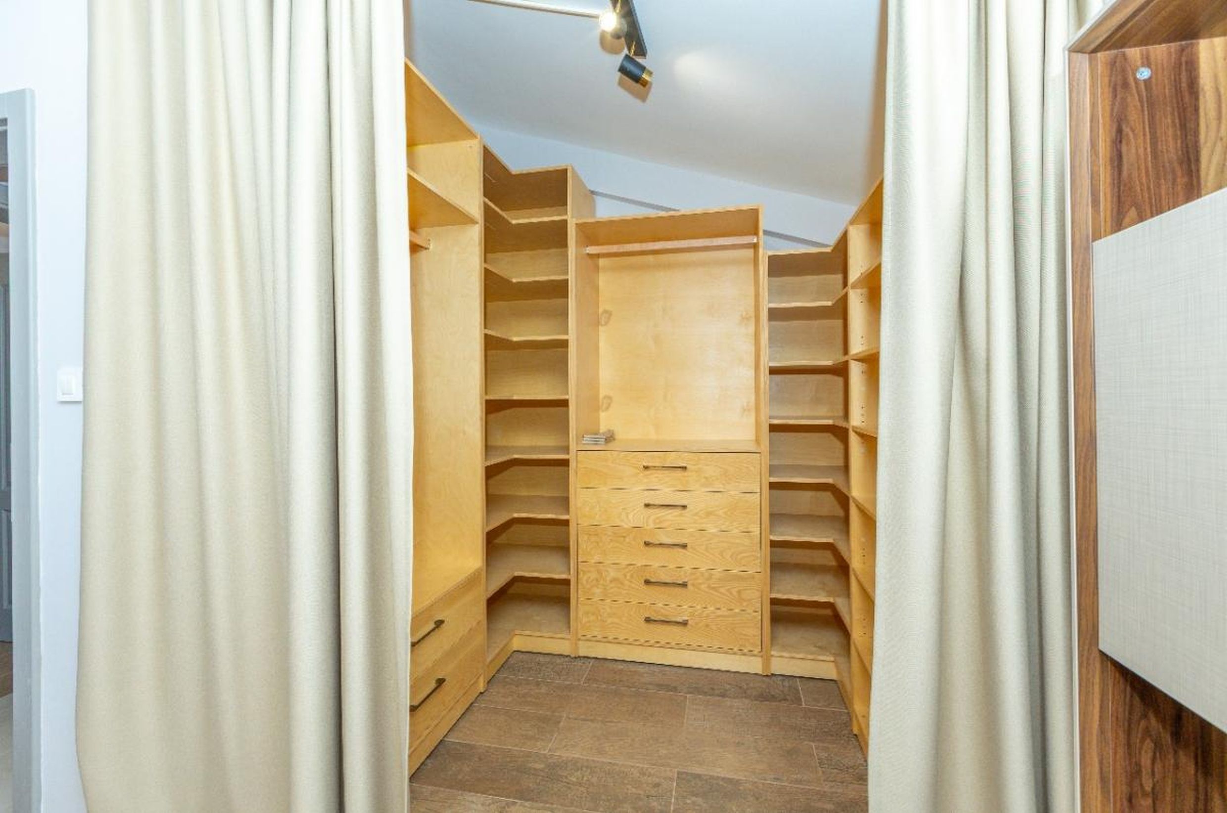 Dressing spacieux avec étagères en bois et commode dans une maison à Tivat, Monténégro.
