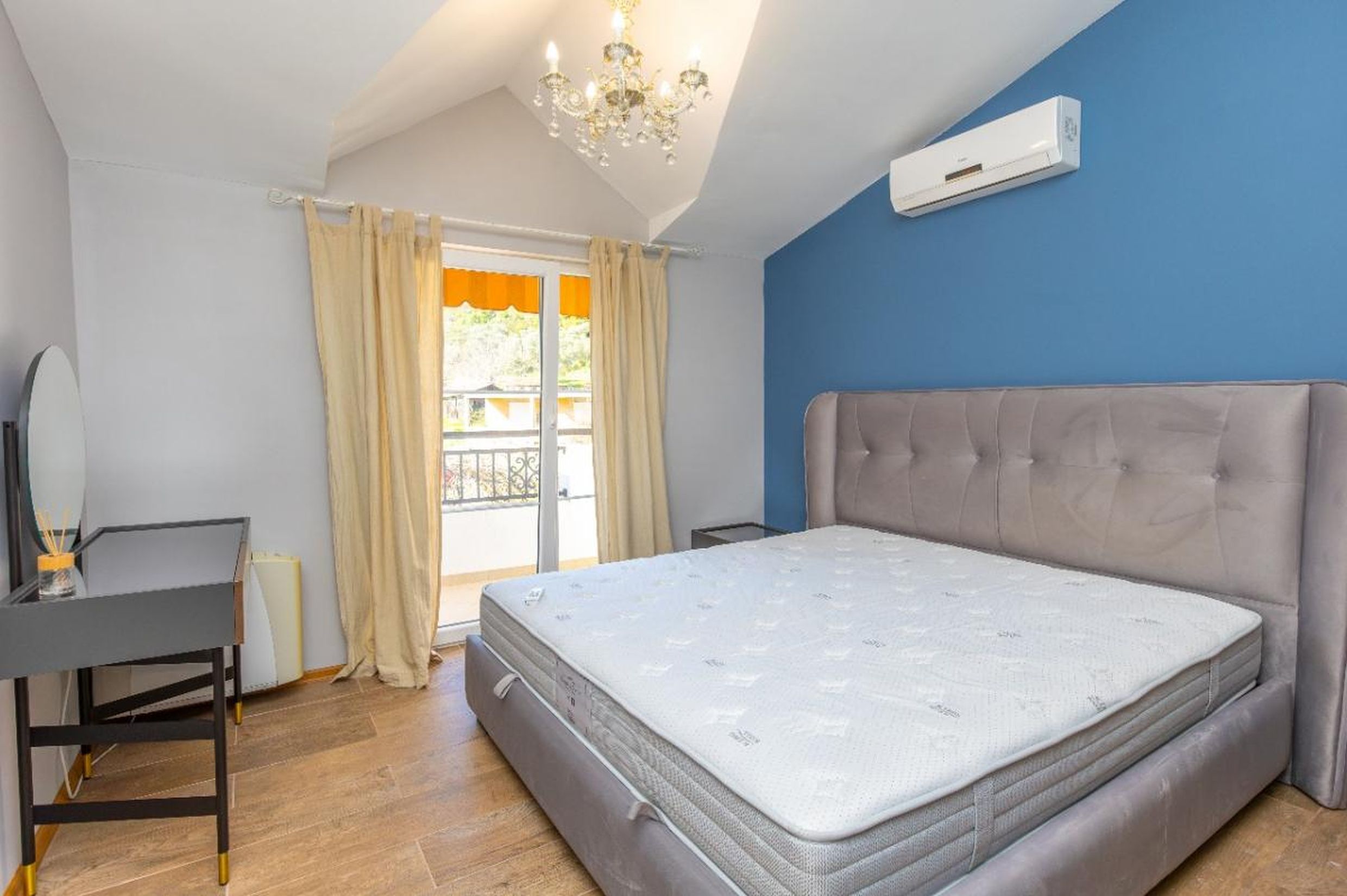 Chambre dans une maison à Tivat, Monténégro : lit double, coiffeuse, accès au balcon et hauts plafonds.