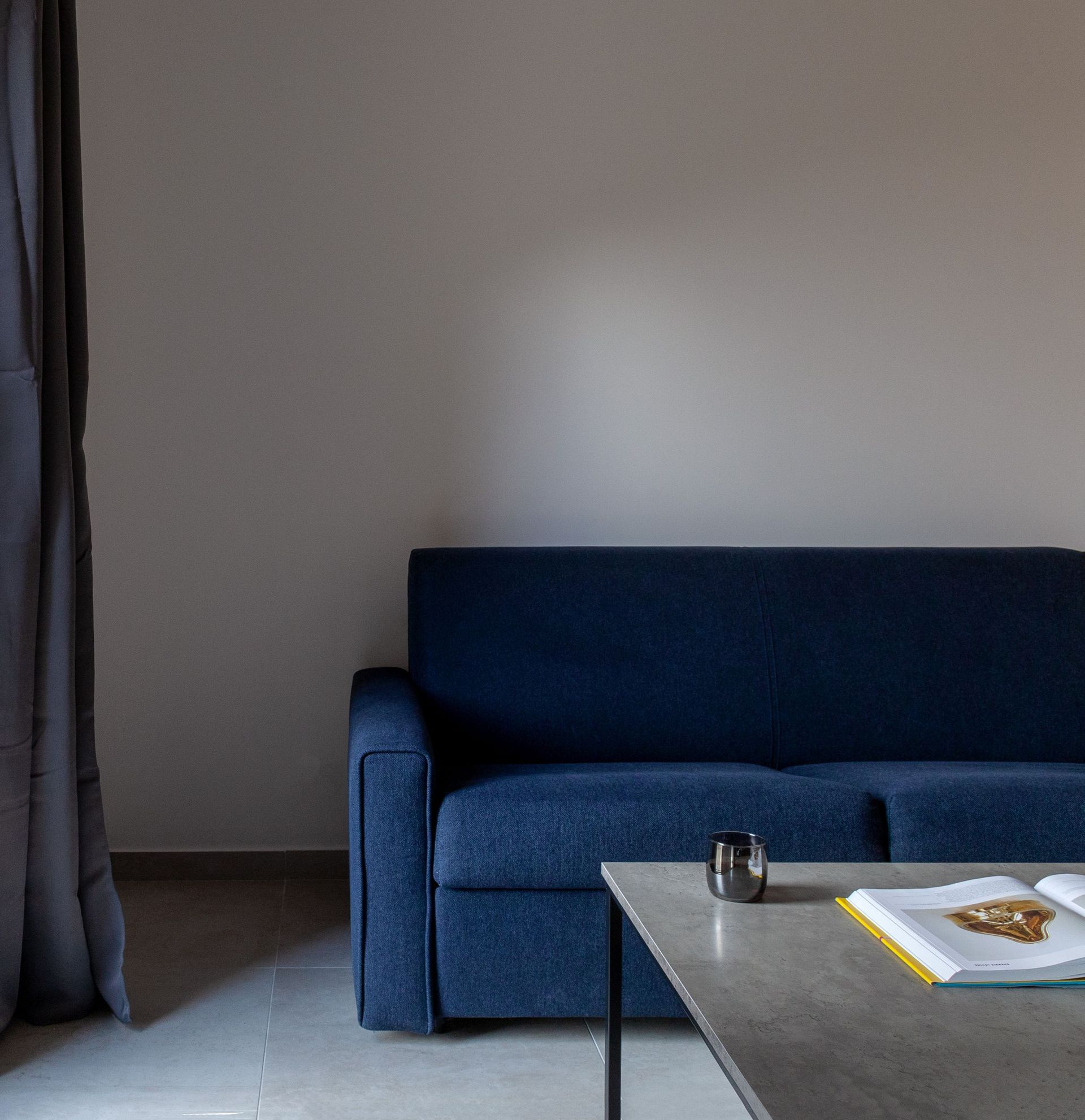 Modernes Wohnzimmer mit blauem Sofa und Couchtisch in einer Wohnung in Kotor, Montenegro.