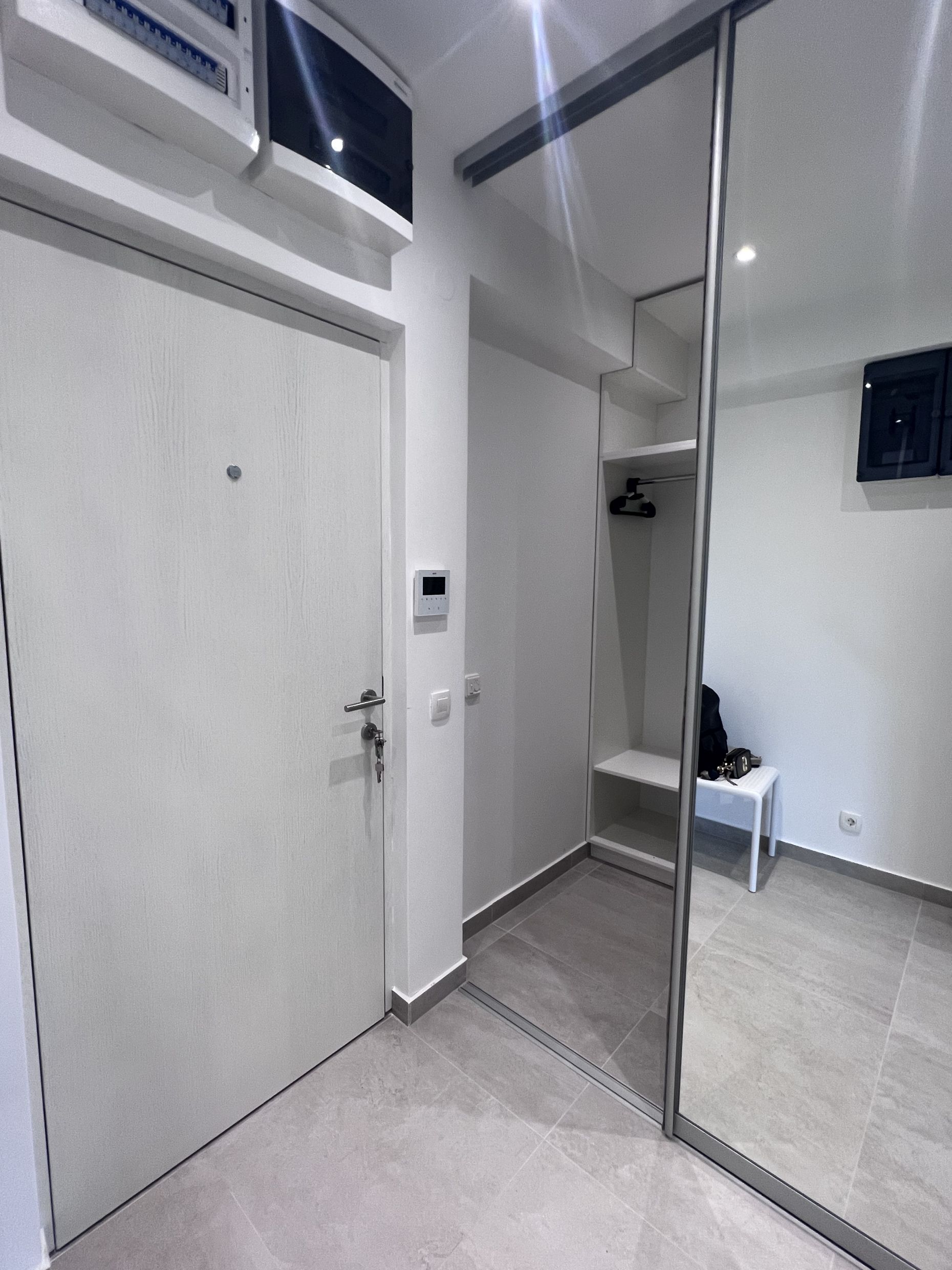 Helle Diele mit Spiegel-Schiebetürschrank in einer modernen Wohnung in Kotor, Montenegro.