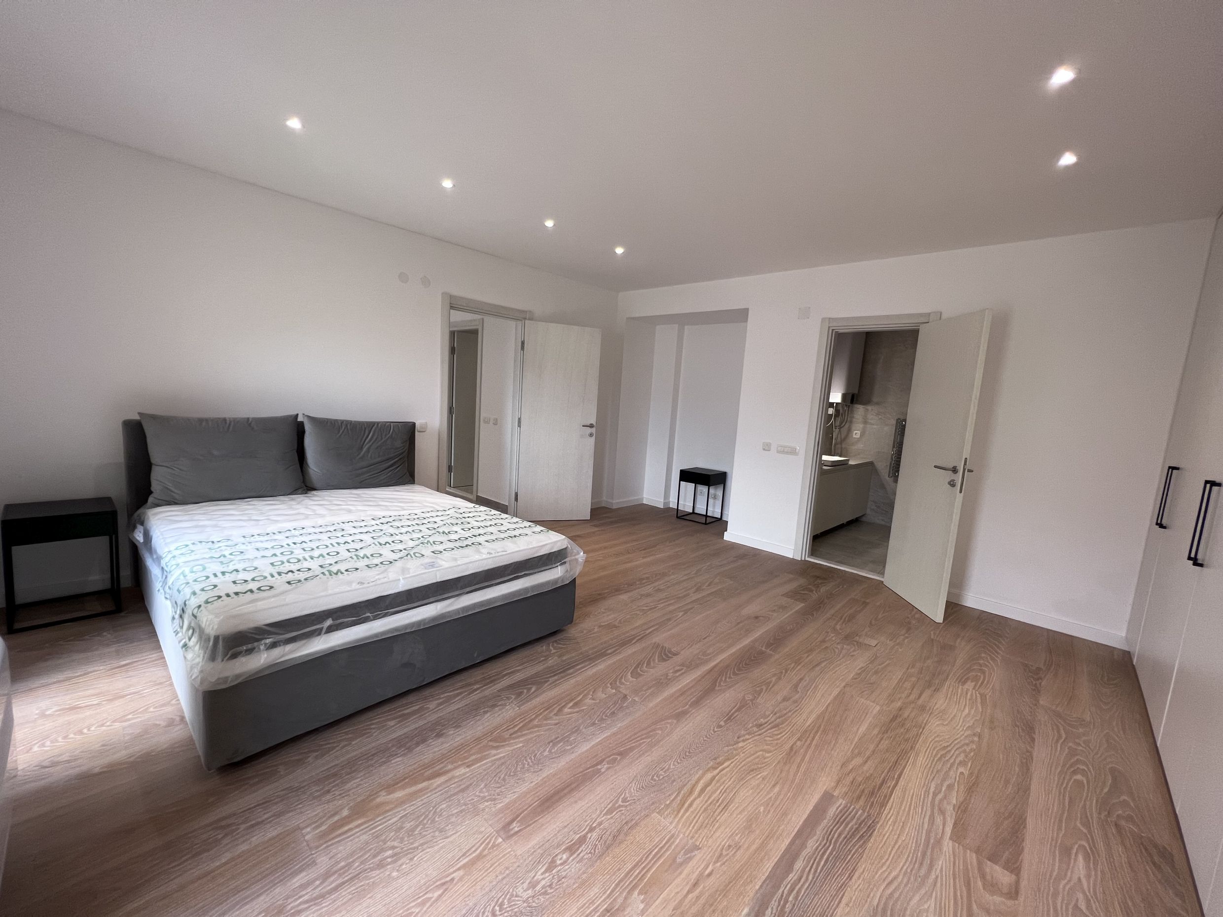 Modernes Schlafzimmer mit Doppelbett und Badezimmer in einer neuen Wohnung, Kotor, Montenegro.