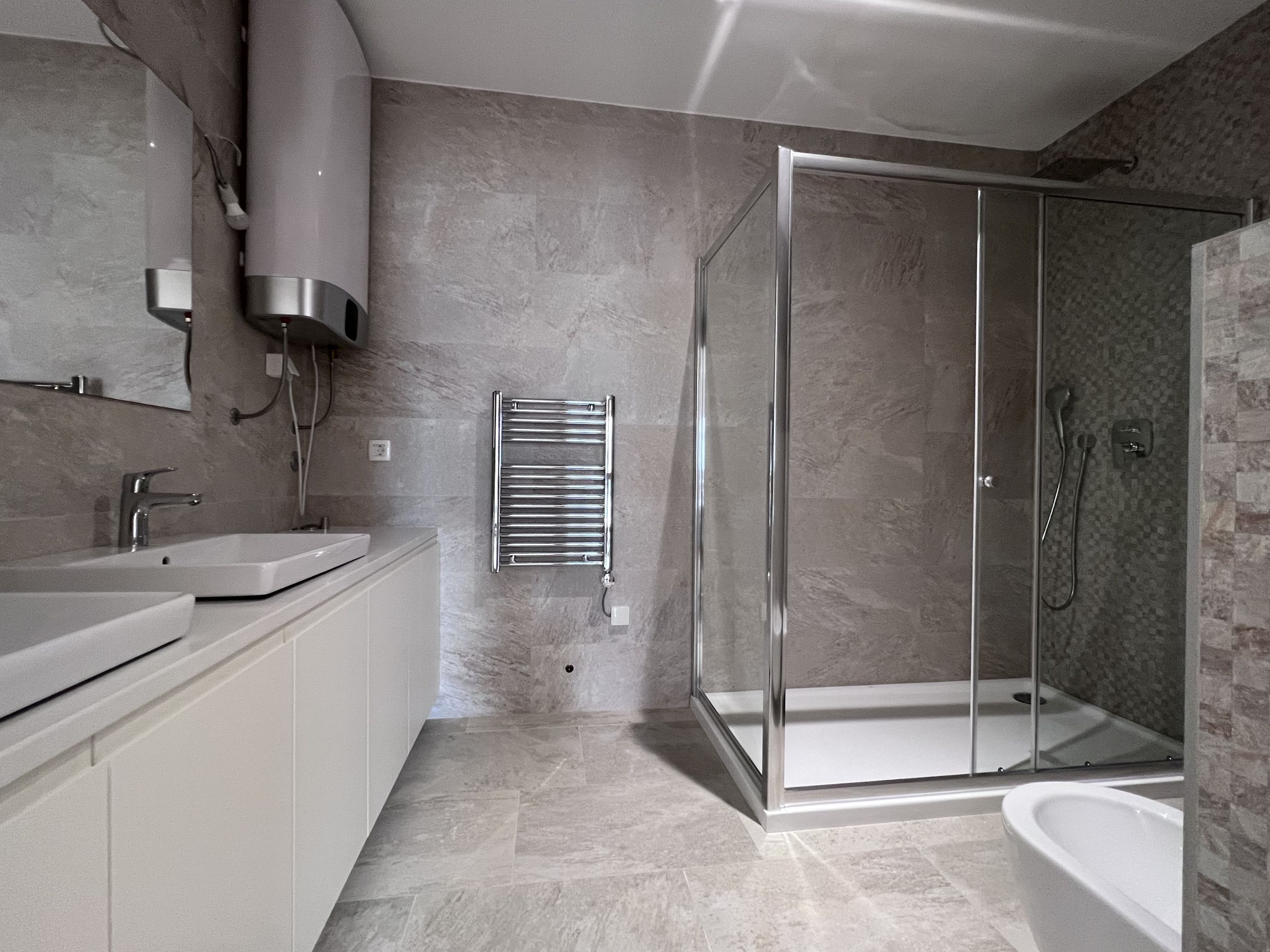 Modernes Badezimmer mit Duschkabine und heller Ausstattung in einer Wohnung, Stadt Kotor, Montenegro.