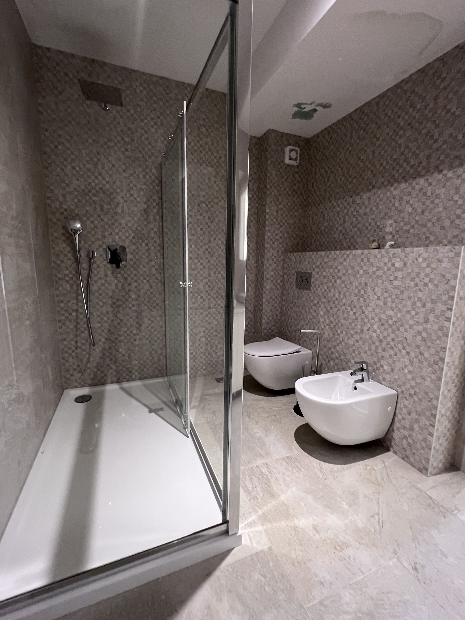 Modernes Badezimmer mit Duschkabine, Hänge-WC und Bidet in einer Wohnung, Kotor, Montenegro.