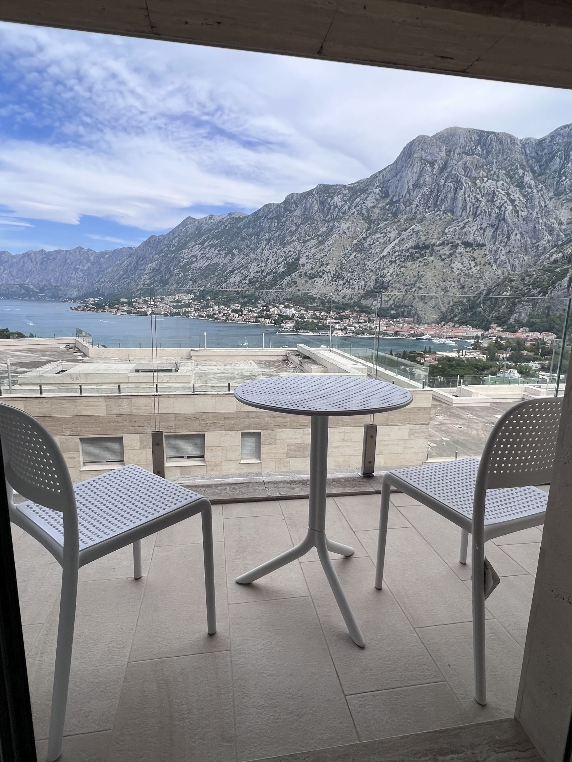 Balkon mit Möbeln und Panoramablick auf die Bucht von Kotor und die Berge, Wohnung in Kotor, Montenegro.