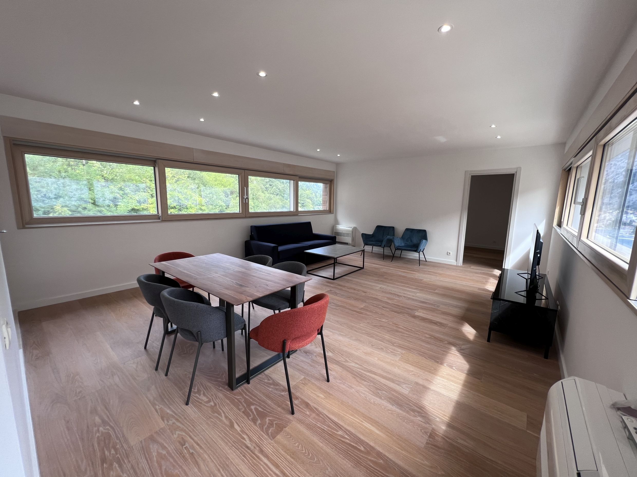 Geräumiges Wohnzimmer mit Essbereich und Panoramafenstern in einer modernen Wohnung, Kotor, Montenegro.