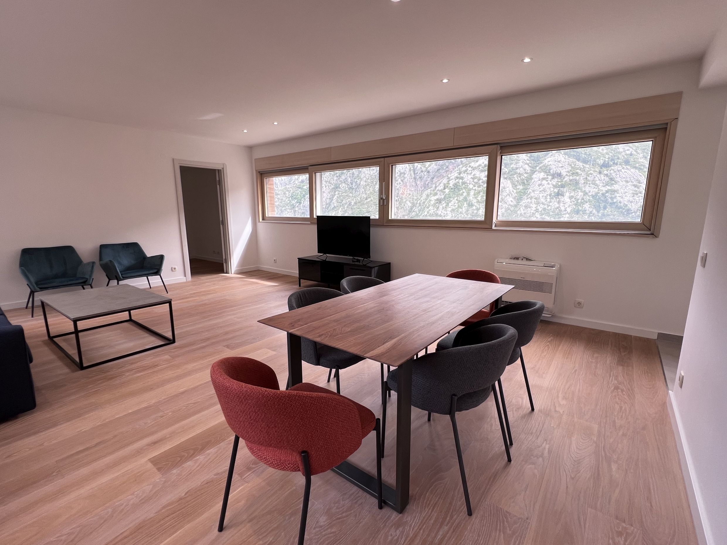 Modernes Wohnzimmer in einer Wohnung in Kotor, Montenegro: Essbereich, Designermöbel und Panoramablick auf die Berge.